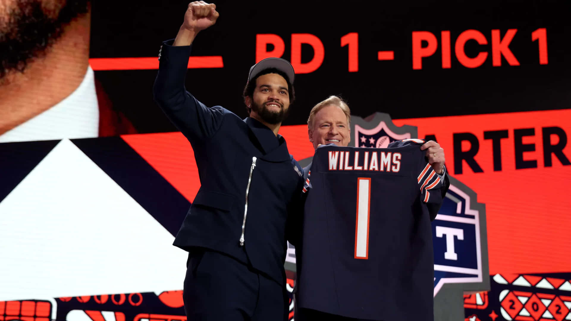 壁紙 — 一位微笑的NFL選秀球員高舉拳頭慶祝，手持印有「WILLIAMS 1」的新球衣，身後「RD 1 - PICK 1」字樣閃耀。
