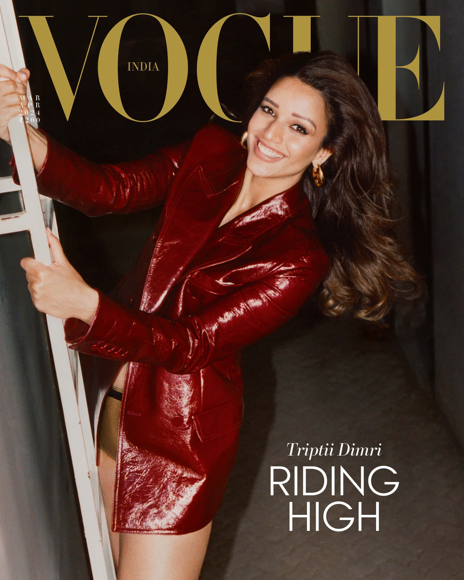  壁紙 — 一位微笑的女性穿著亮面紅色皮夾克，靠在梯子上，出現在Vogue India雜誌封面。