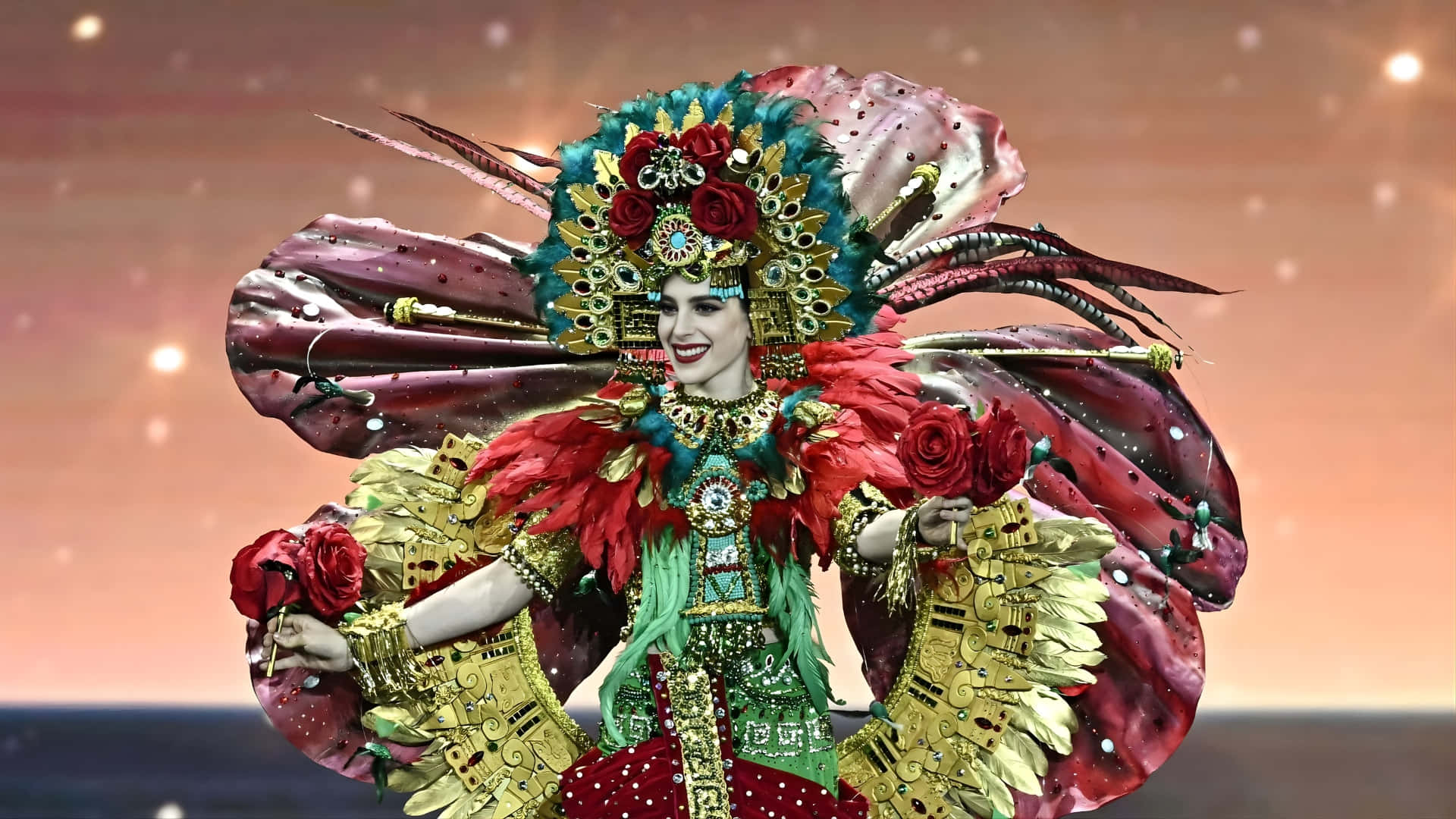  壁紙 — 一位耀眼的表演者身穿華麗的紅、金、綠色羽毛服裝，在溫暖發光的天空下微笑。