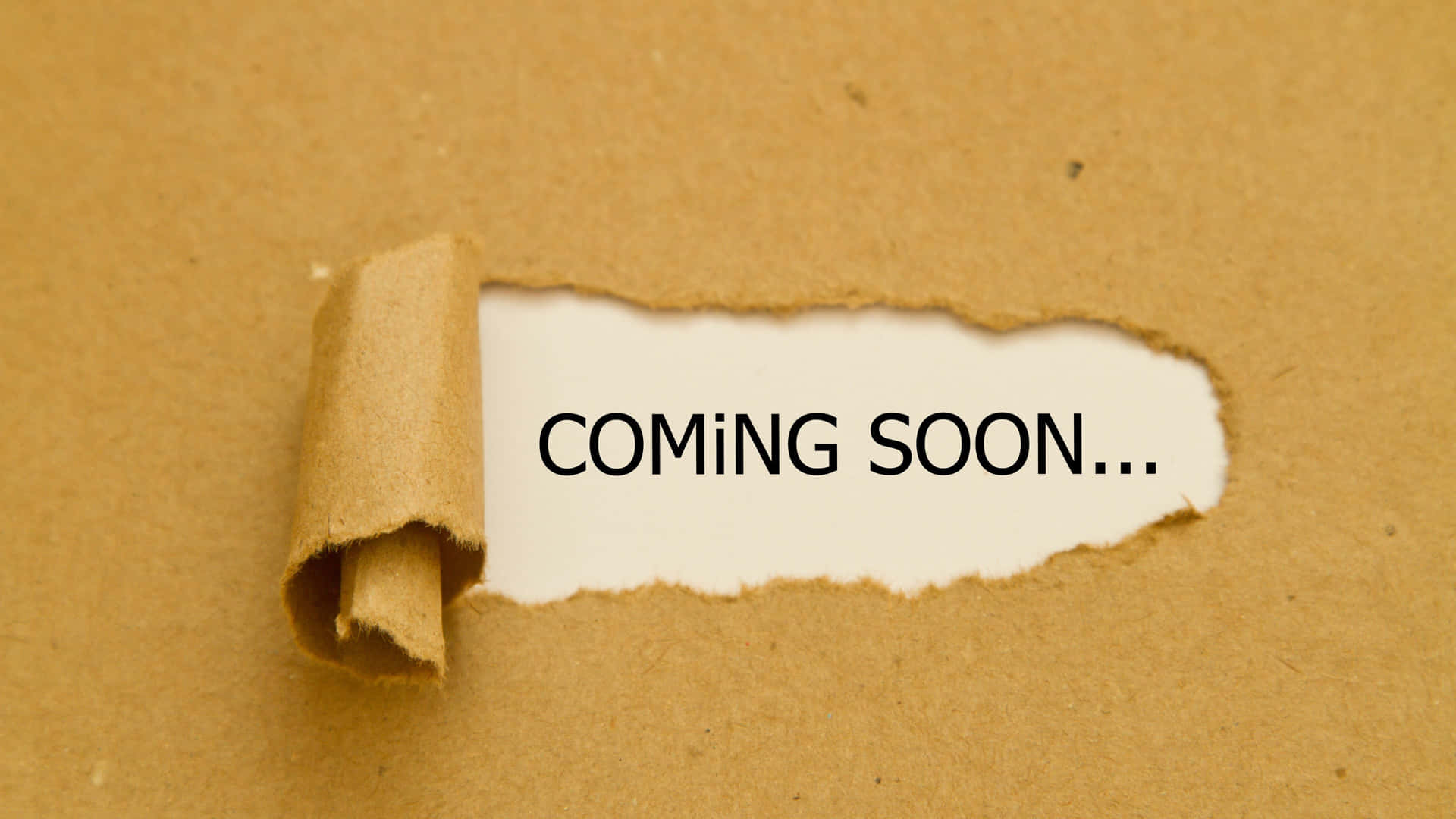 破爛的棕色紙張露出「COMING SOON...」文字。