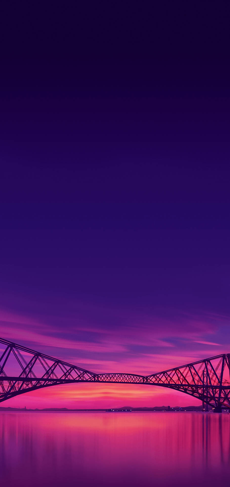 夕陽下的橋樑，紫色和粉紅色的天空倒映在水中。
