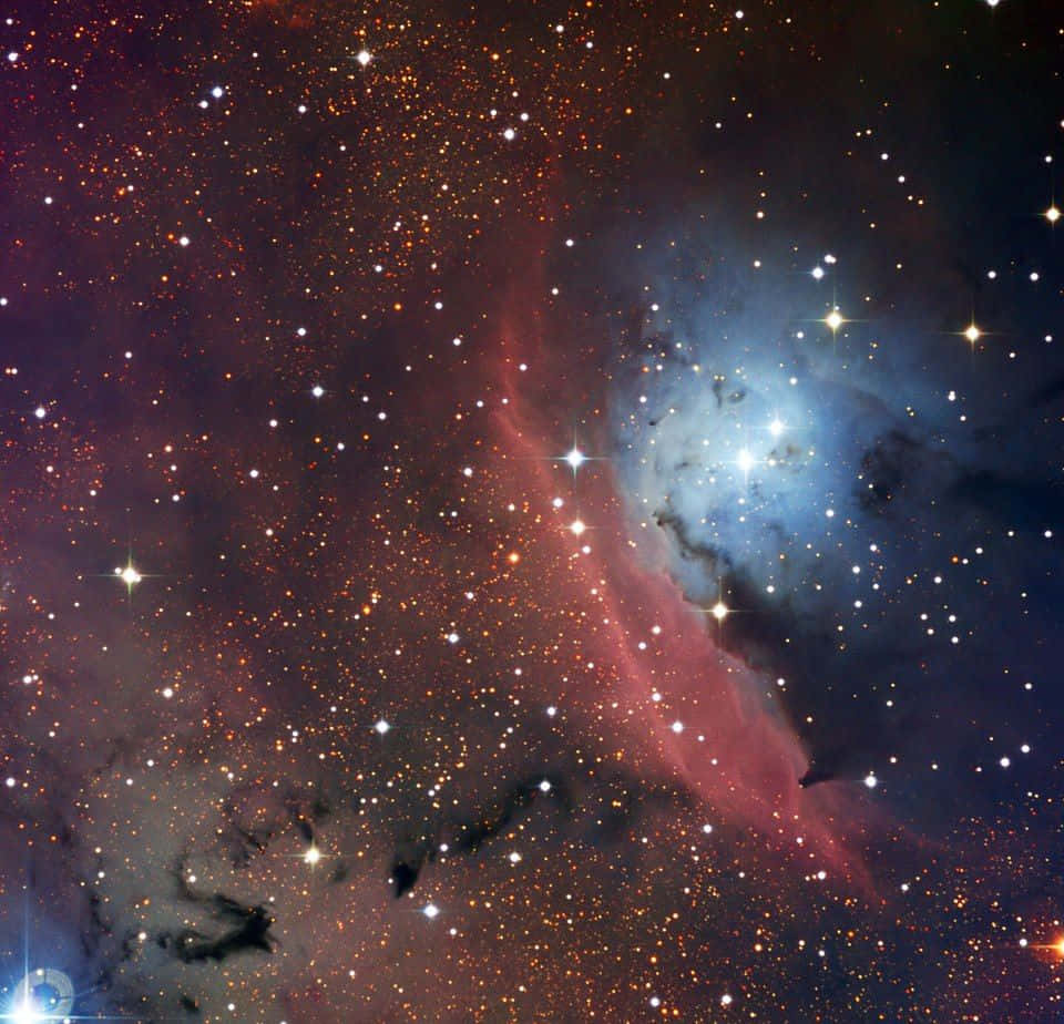 Interstellar Cloud 桌布 壁紙 — 一個充滿活力的宇宙星雲，散發著紅色和藍色的氣體雲，周圍環繞著無數閃爍的星星。