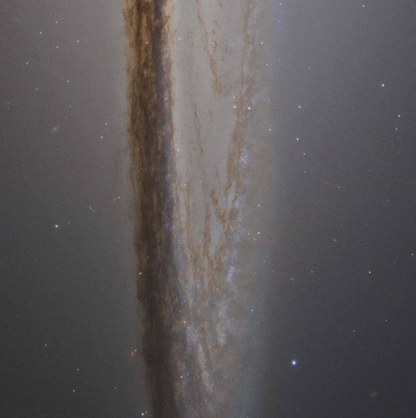  壁紙 — 一個宏偉的螺旋星系垂直延伸穿過星場，帶有旋轉的塵埃臂和發光的恆星。