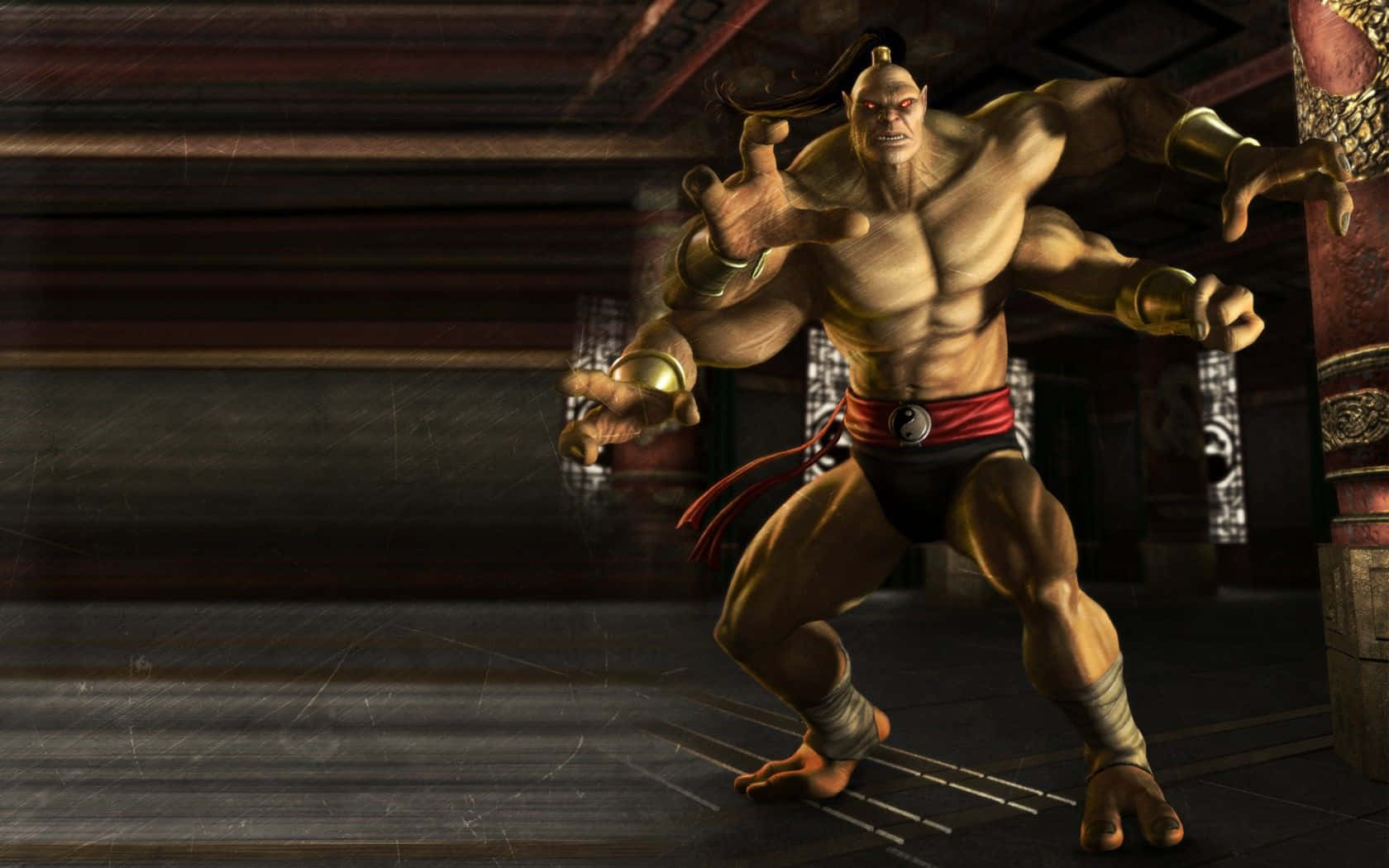 Mortal Kombat Goro 桌布 壁紙 — 一個肌肉發達的光頭戰士，紅眼睛，戴著金色臂環，在光線昏暗的傳統道場中擺出戰鬥姿勢。