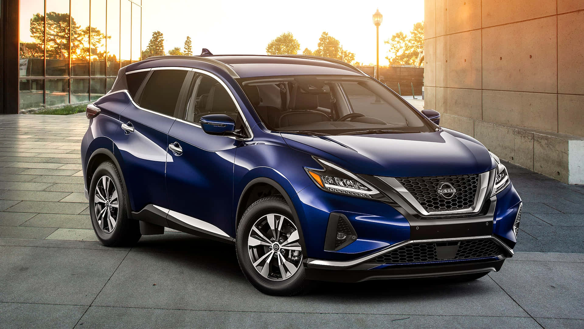 Nissan Murano 桌布 壁紙 — 一架時尚的藍色日產Rogue SUV停泊在現代瓷磚廣場上，正值黃金時刻，溫暖的陽光投下長長的影子。