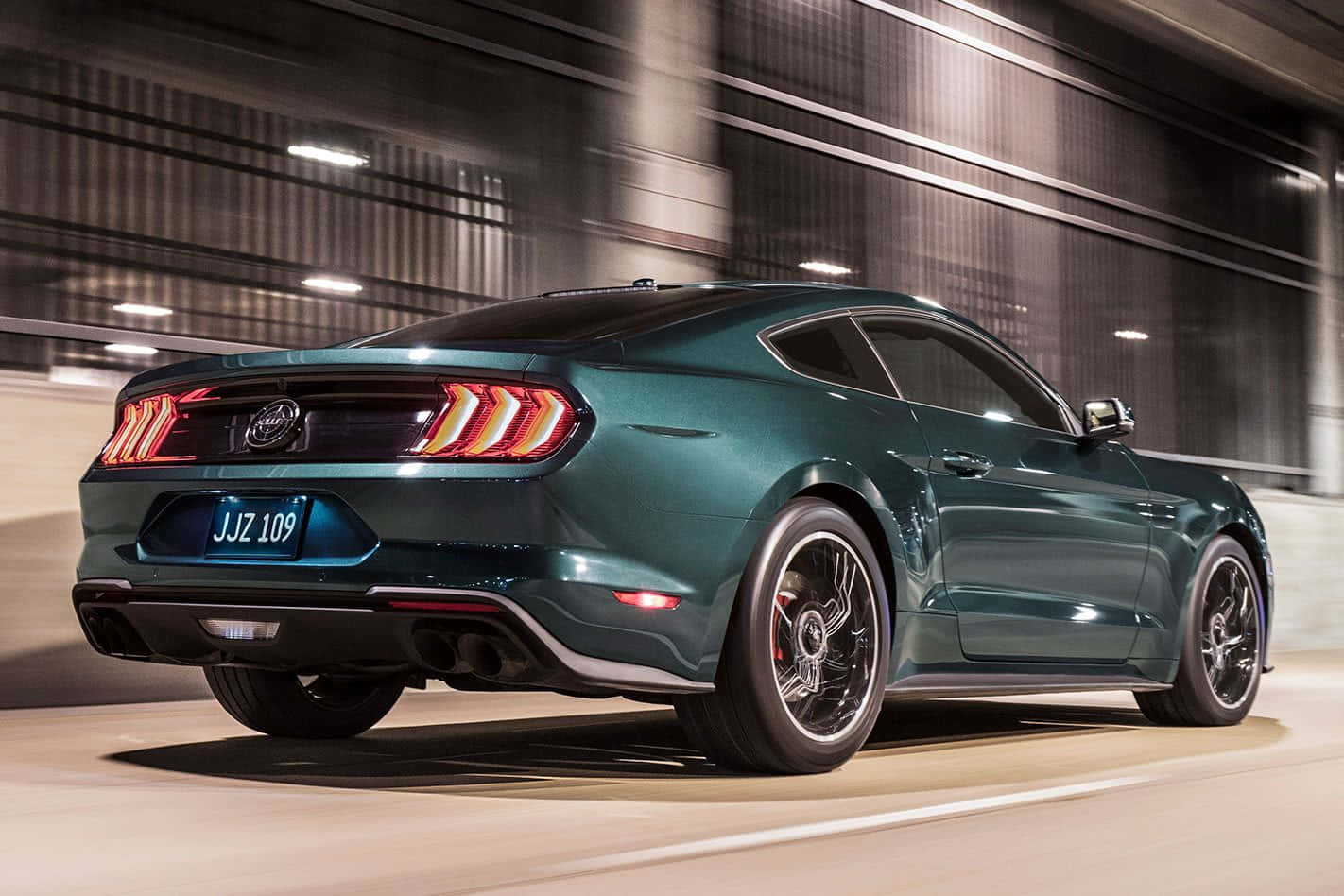 Ford Mustang Bullitt 桌布 壁紙 — 一架流線型青綠色福特野馬在燈光昏暗的隧道中疾馳，尾燈閃爍，帶有動態模糊效果。