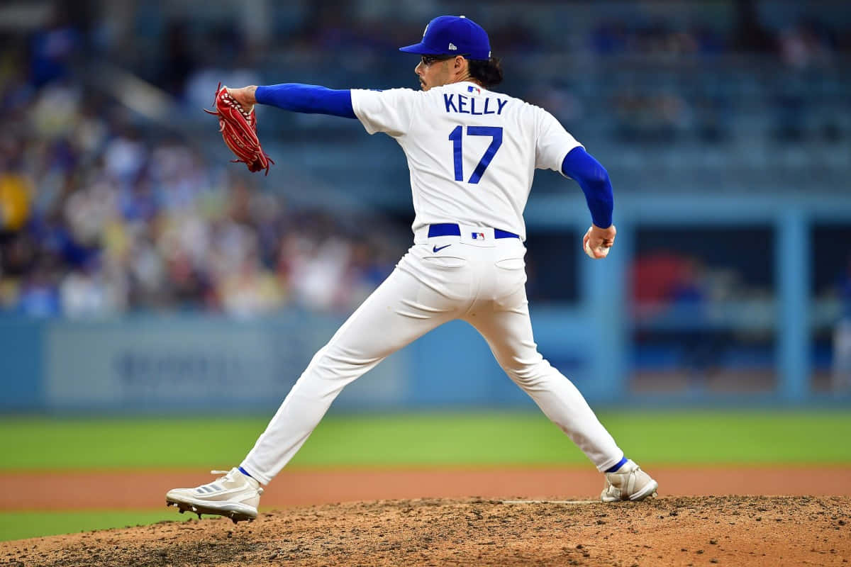  壁紙 — 一名身穿白色和藍色球衣、名字為Kelly、背號17的棒球投手在比賽中於投手丘上揮臂準備投球。