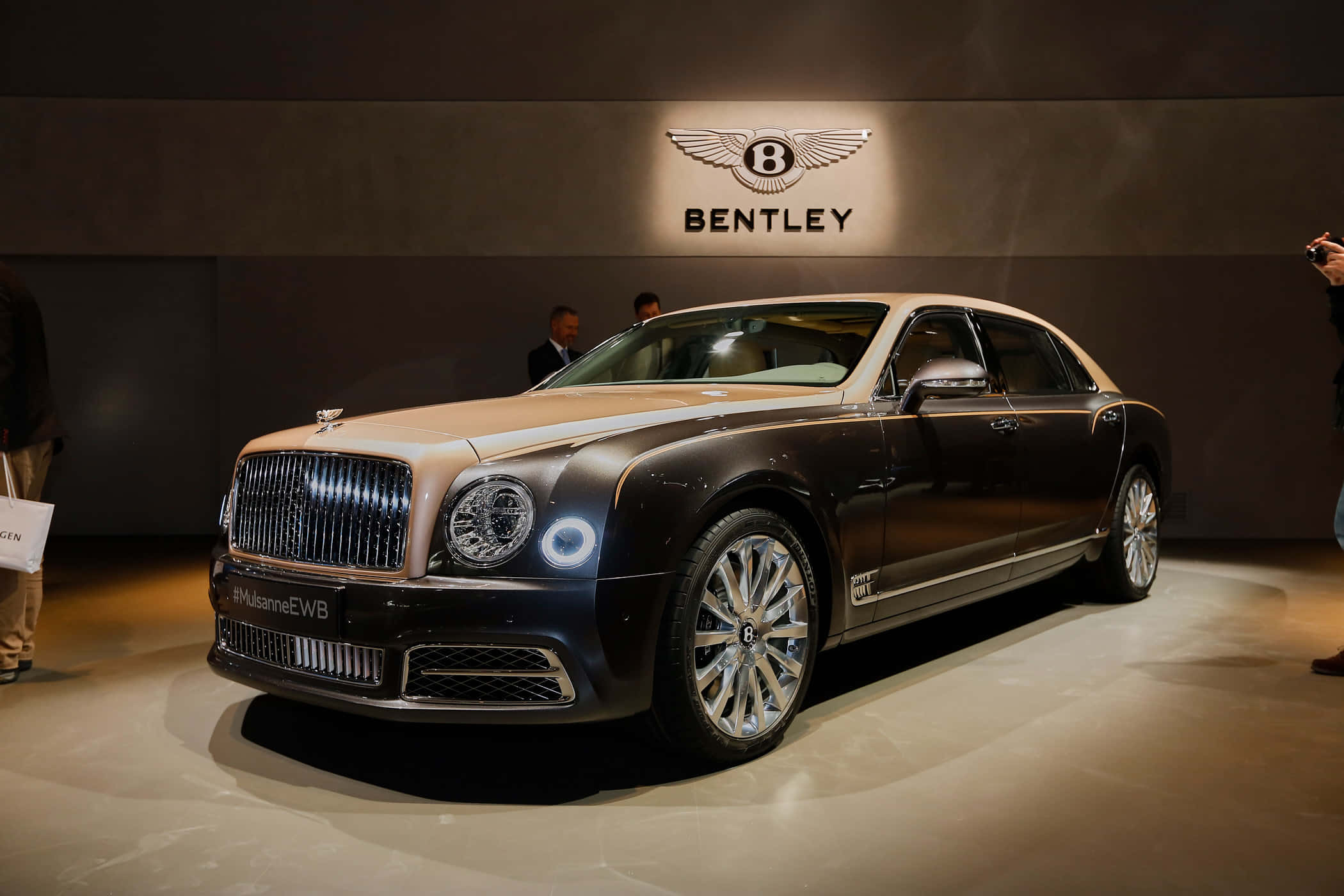 Bentley Mulsanne 桌布 壁紙 — 一輛豪華的賓利Mulsanne EWB轎車在室內車展的聚光燈下閃閃發光，與會者正在觀看。