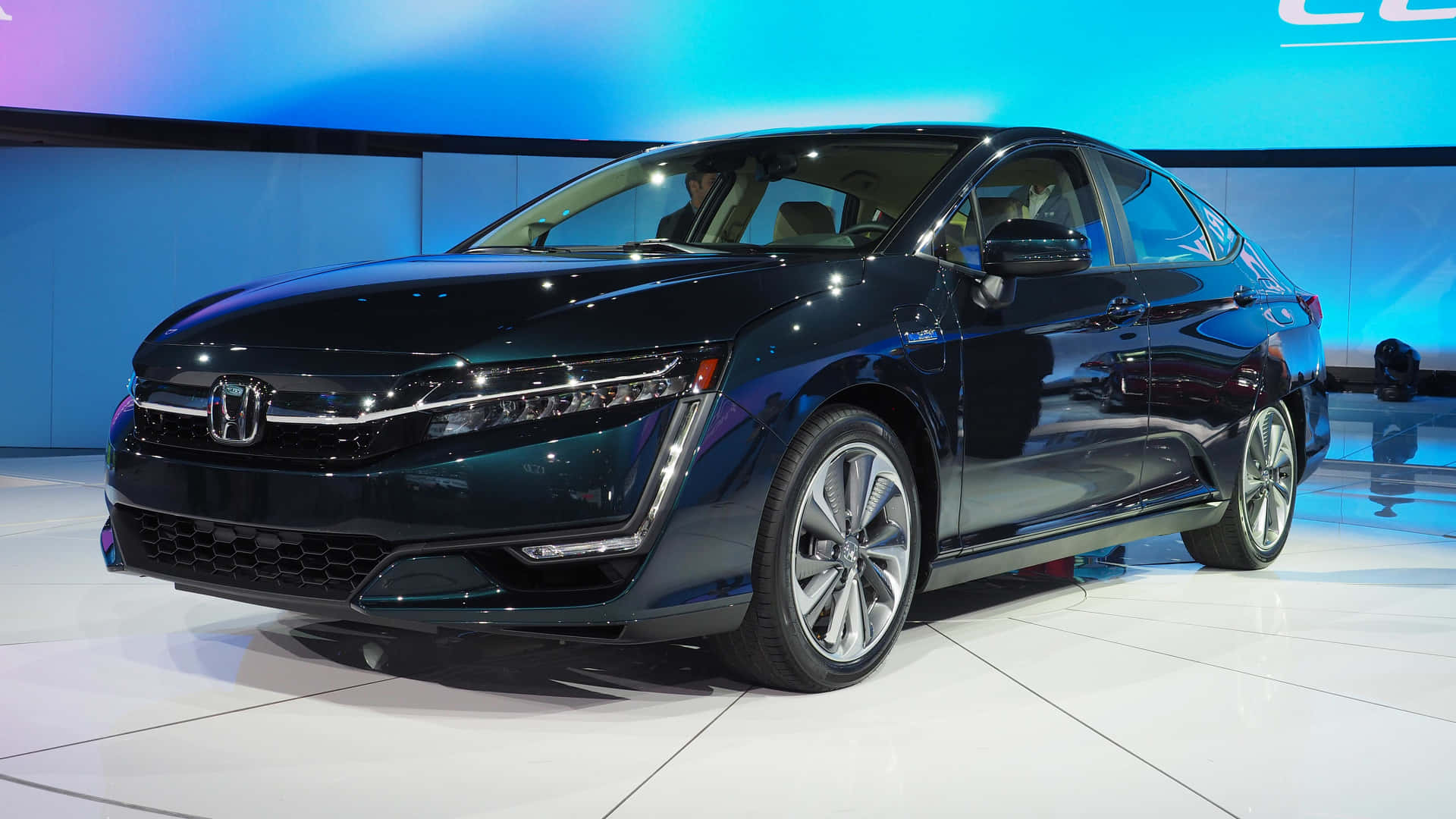 Honda Clarity 桌布 壁紙 — 一輛時尚的黑色本田轎車在白色展廳地板上，在藍色背景燈光下閃閃發光。