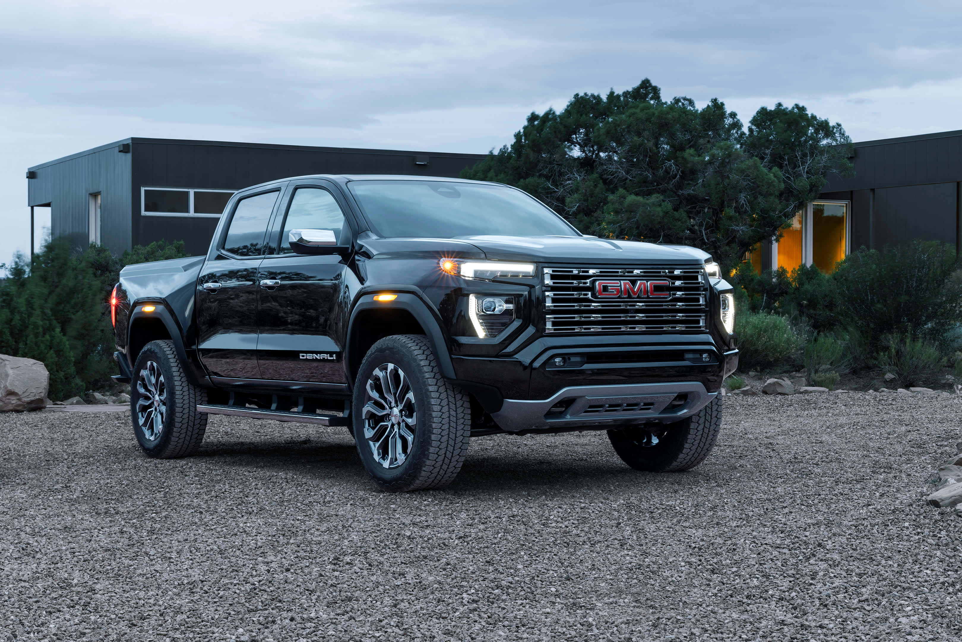 Gmc Canyon 桌布 壁紙 — 一輛時尚的黑色GMC Sierra Denali皮卡車在黃昏時停泊在現代房屋前的碎石路上。