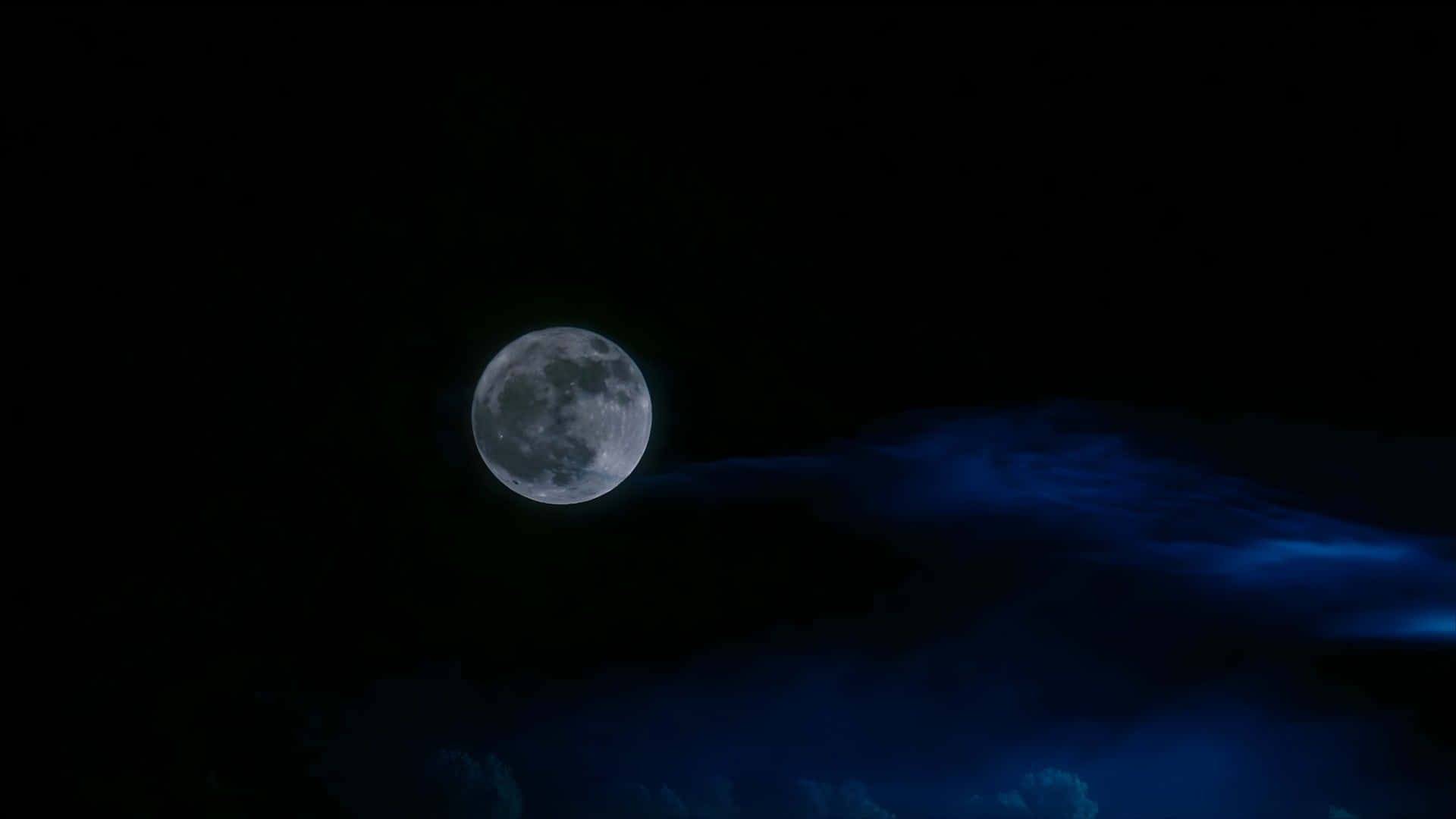  壁紙 — 一輪明亮的滿月在黑暗的天空中發光，下方有旋轉的藍色雲層。