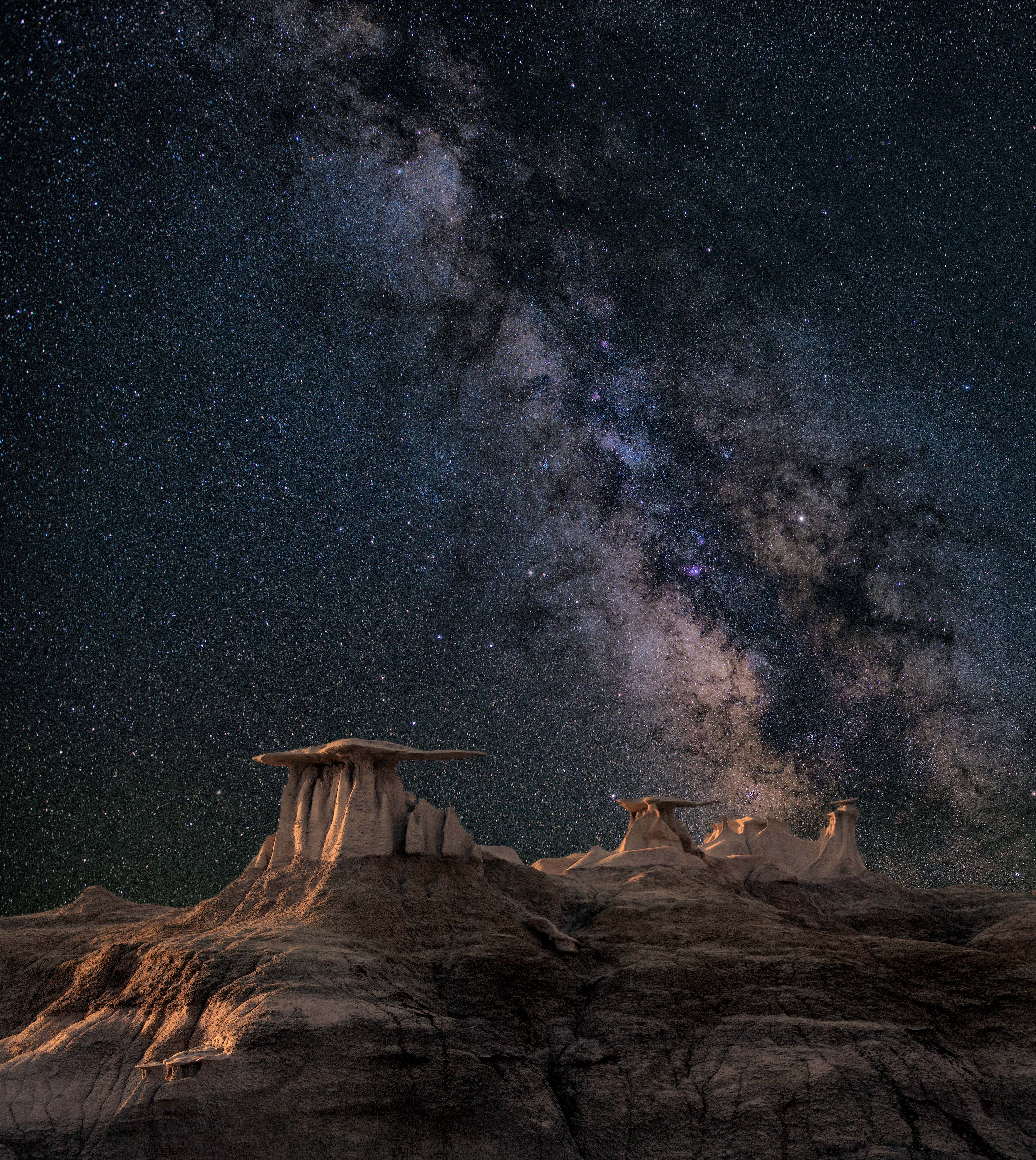 派大星在蔚藍海洋下享受時光 壁紙 — 銀河系在繁星點點的沙漠夜空下，在戲劇性的hoodoo岩層上拱起。
