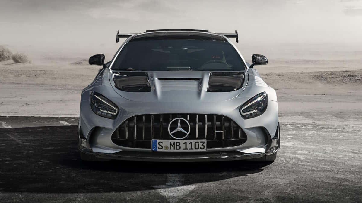 Mercedes Benz Amg Gt 桌布 壁紙 — 一架銀色 Mercedes-AMG GT Black Series 跑車帶有後擾流板，停泊在塵土飛揚的沙漠公路上，天空朦朧。