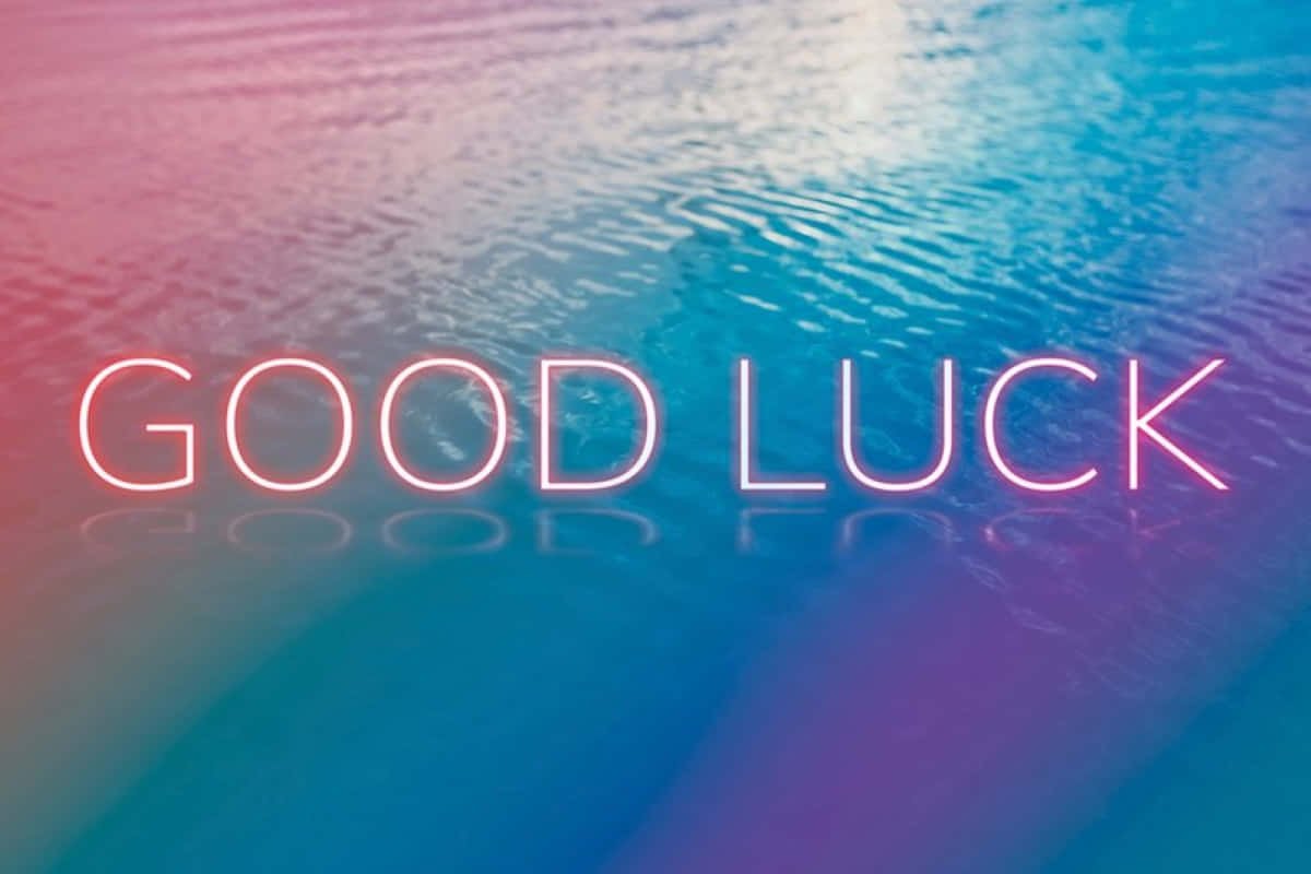  壁紙 — 螢光粉紅和藍色 'GOOD LUCK' 文字漂浮在漣漪水面上，帶有漸變倒影。
