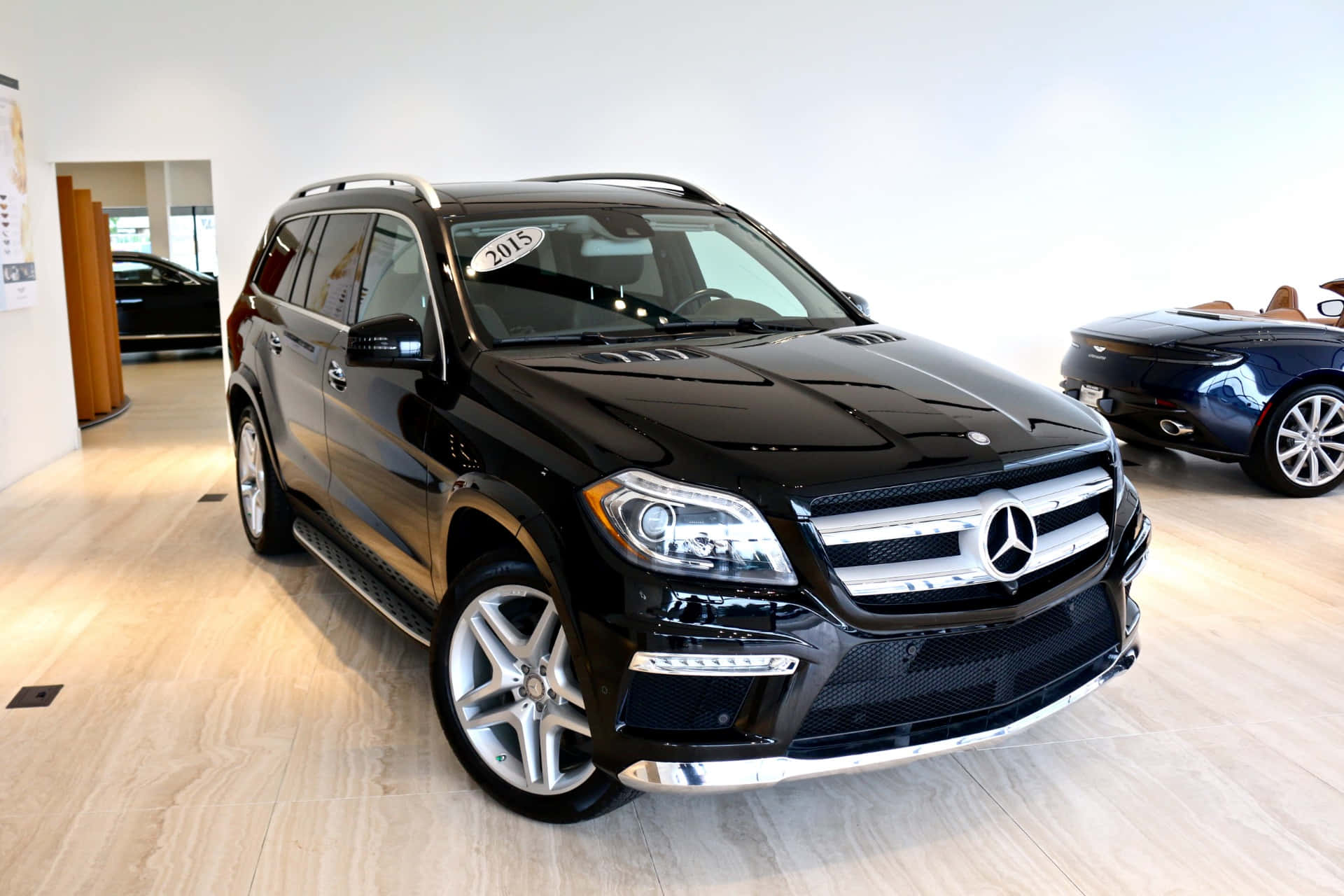 Mercedes-benz Gl-class 桌布 壁紙 — 一輛光亮的黑色平治GL-Class SUV在展廳燈光下閃耀，配備鍍鉻飾件和合金輪圈。