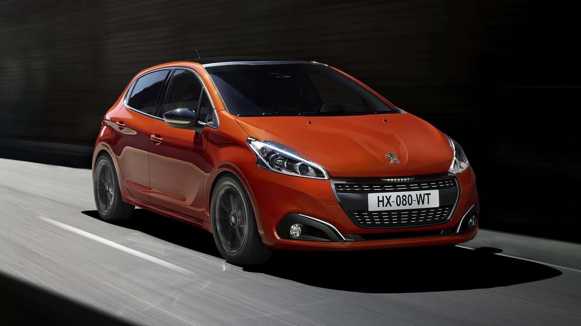 Peugeot 208 桌布 壁紙 — 一輛充滿活力的橙色Peugeot 208在戲劇性的工作室燈光下，在模糊的道路上疾馳。