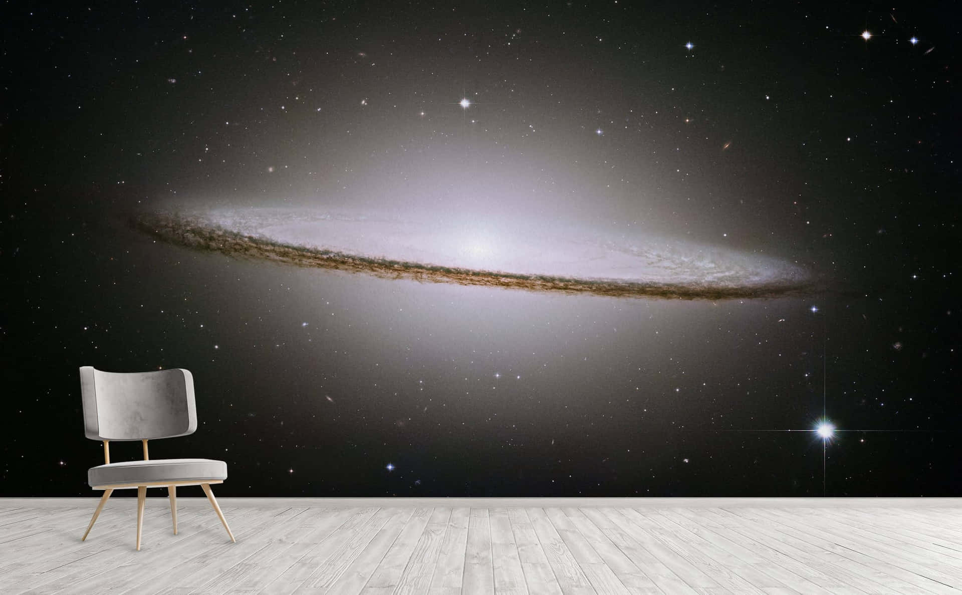  壁紙 — 一張現代單椅放在一幅描繪發光螺旋星系與星空的廣闊宇宙壁畫前。