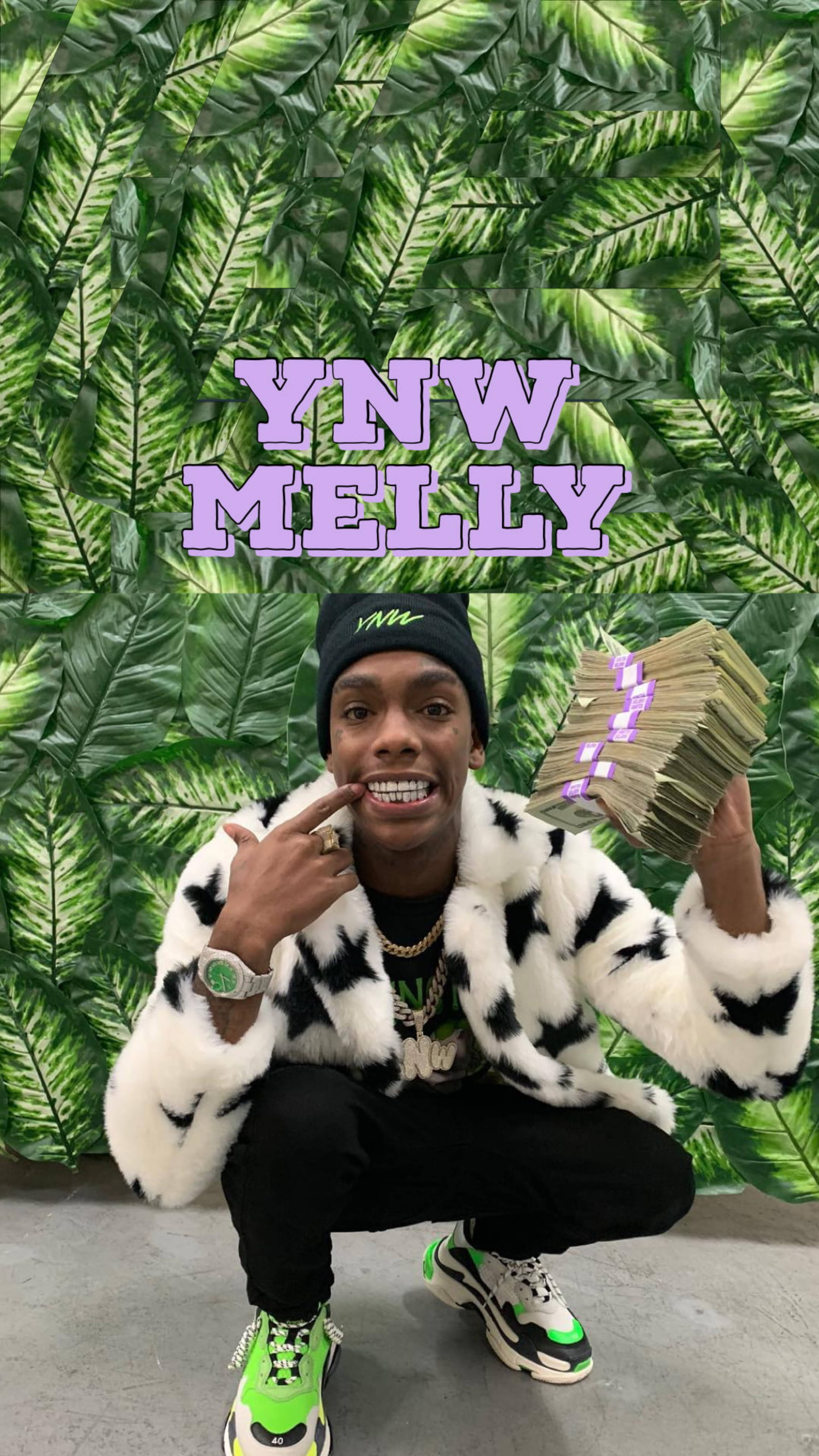 YNW Melly 綠色系 壁紙 — 一名身穿黑白皮草大衣的男子蹲著，手持現金，背景是綠色樹葉，並有「YNW MELLY」字樣。