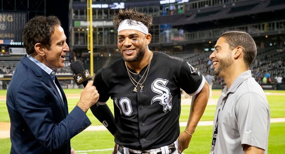 Yoan Moncada 接受訪問 壁紙 — 一名身穿黑色芝加哥白襪隊球衣的棒球運動員在夜間燈光球場上接受訪問時微笑。