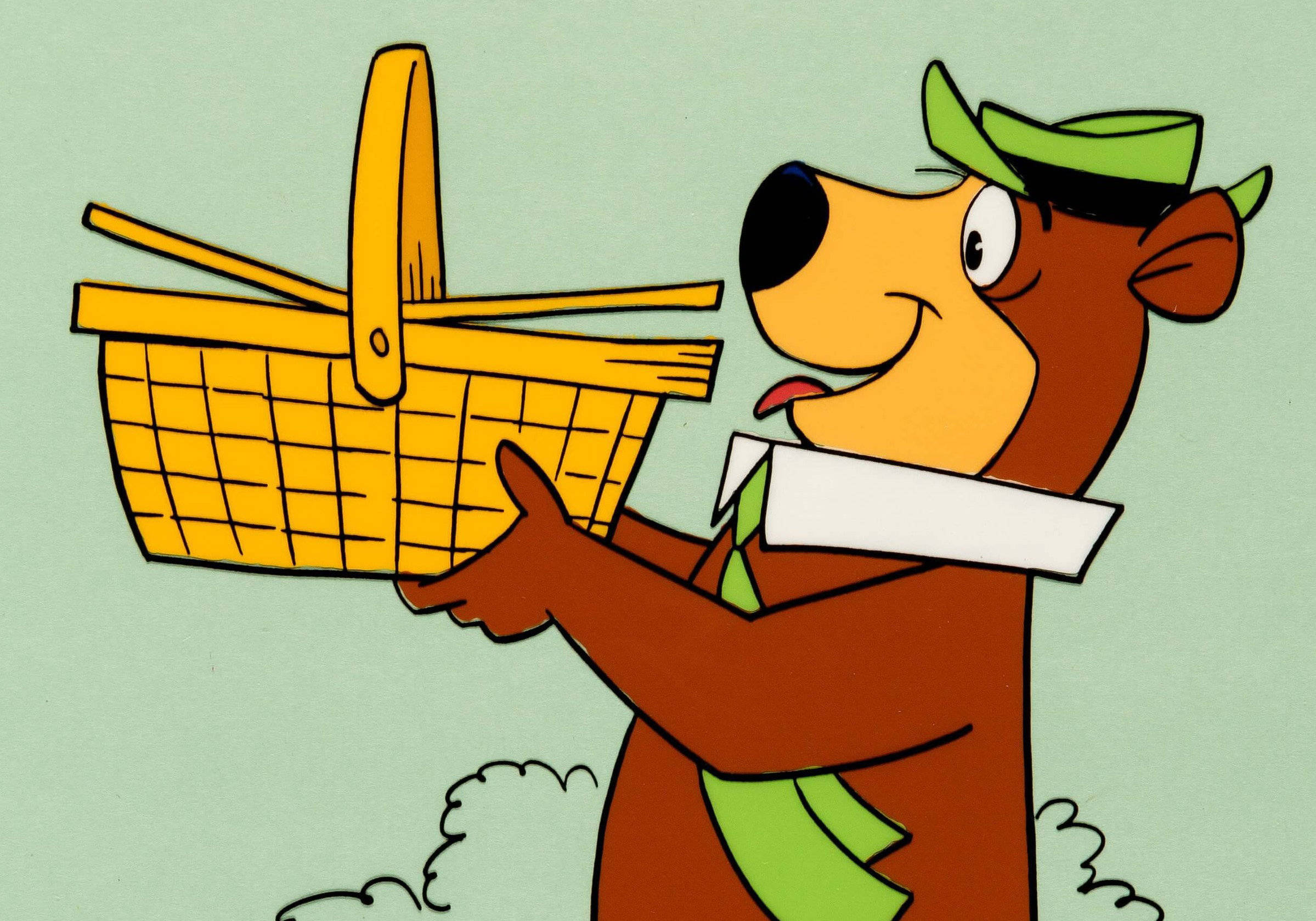 Yogi Bear 的野餐籃 壁紙 — 一隻戴著綠色帽子和圍巾的開心卡通熊，在柔和的薄荷色背景前自豪地拿著一個黃色野餐籃。