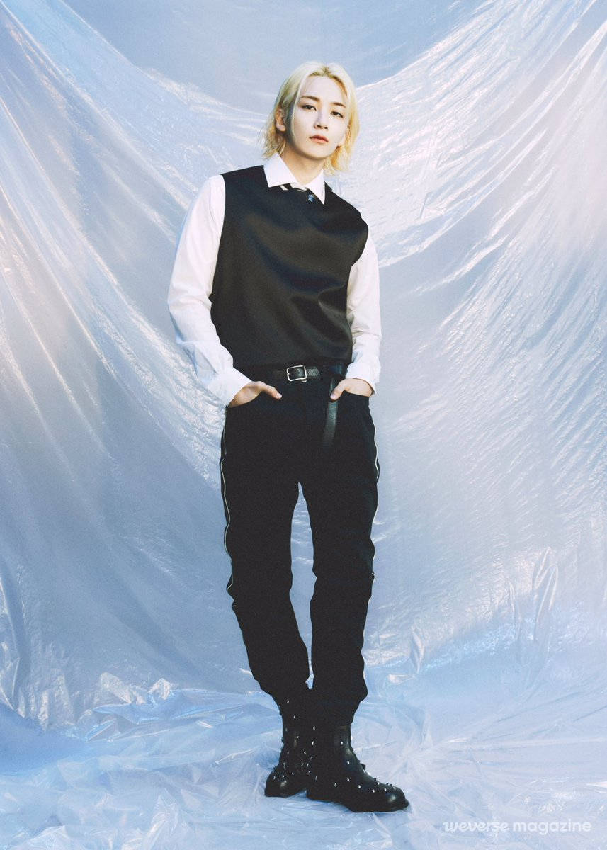 Yoon Jeonghan Weverse 雜誌 壁紙 — 一位金髮人士自信地穿著黑色背心和褲子，站在皺褶的半透明藍色背景前。