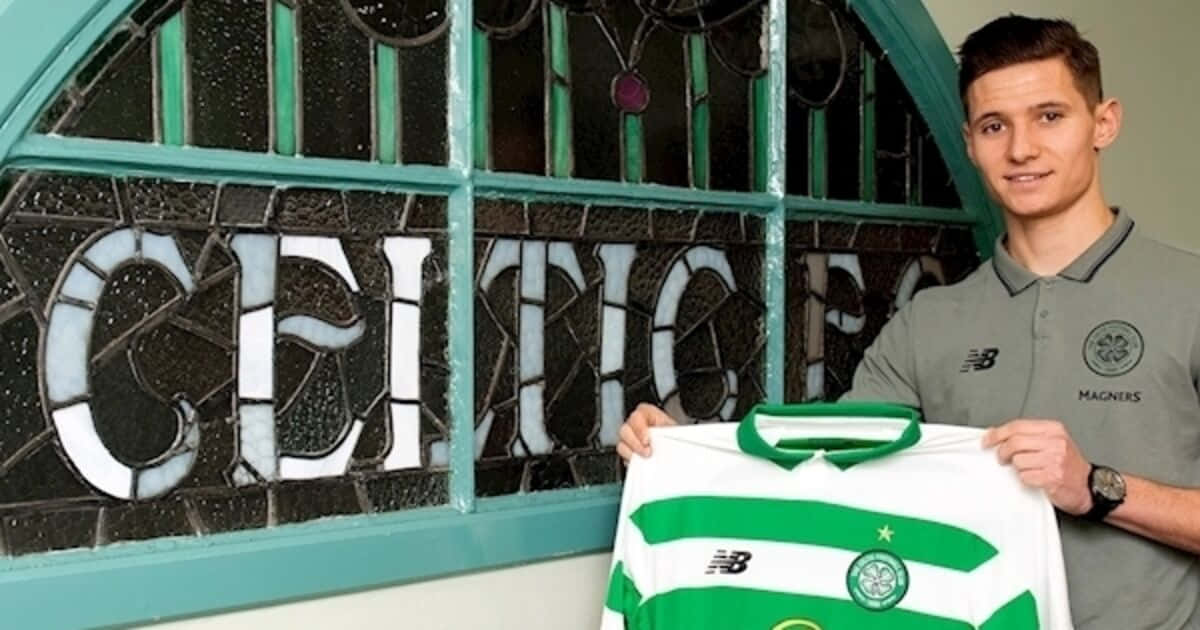  壁紙 — 一名身穿些路迪FC Polo衫的年輕男子，在寫有「CELTIC」的彩繪玻璃窗前自豪地舉起一件綠白間條足球球衣。