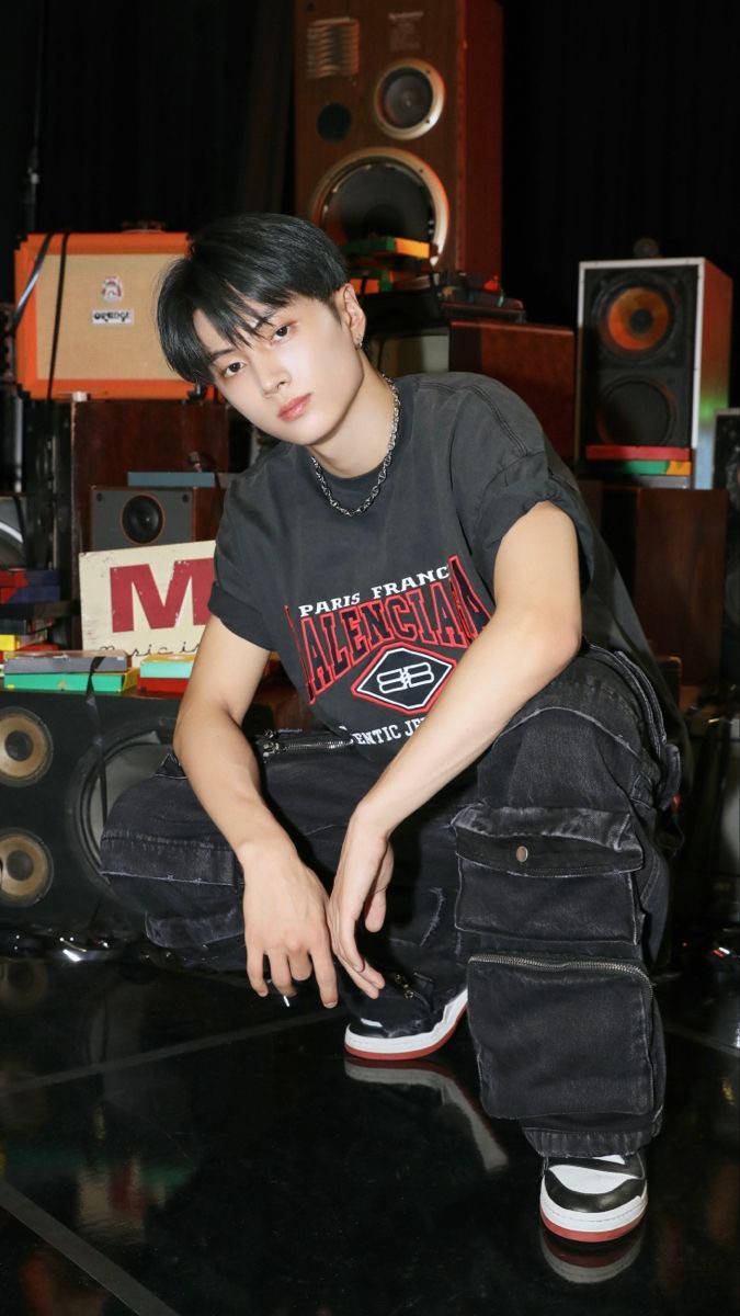 年輕男子在音樂錄音室中與復古音響設備合影。