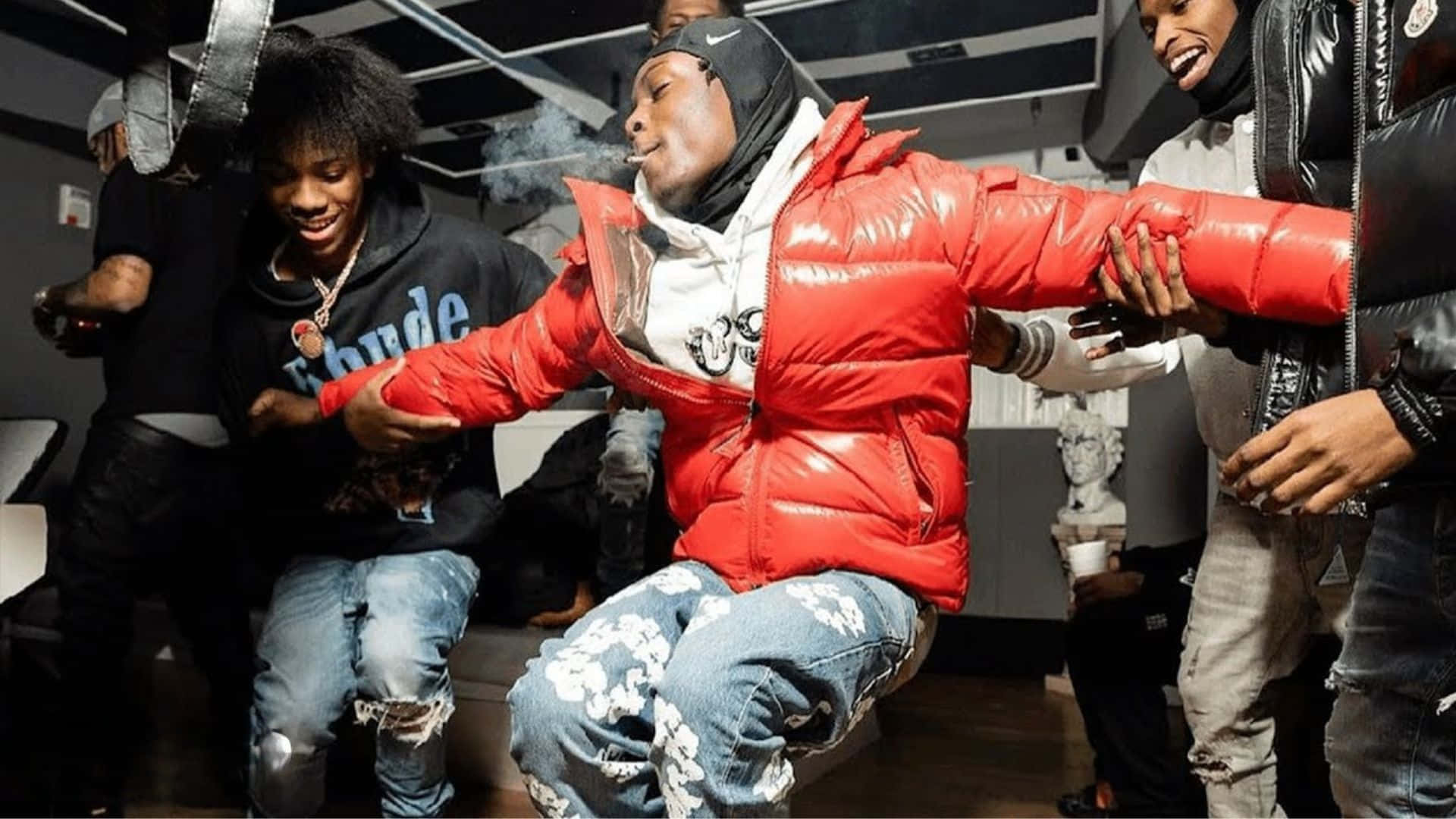  壁紙 — 一群穿著都市街頭服的年輕男子在光線昏暗、天花板橫樑外露的房間裡一起大笑和吸煙。