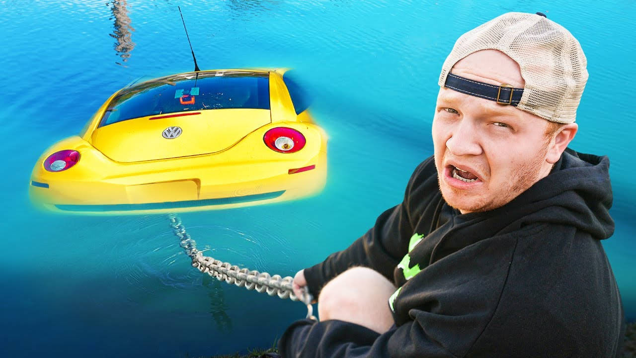 男子用鏈條將黃色汽車從水中拉出