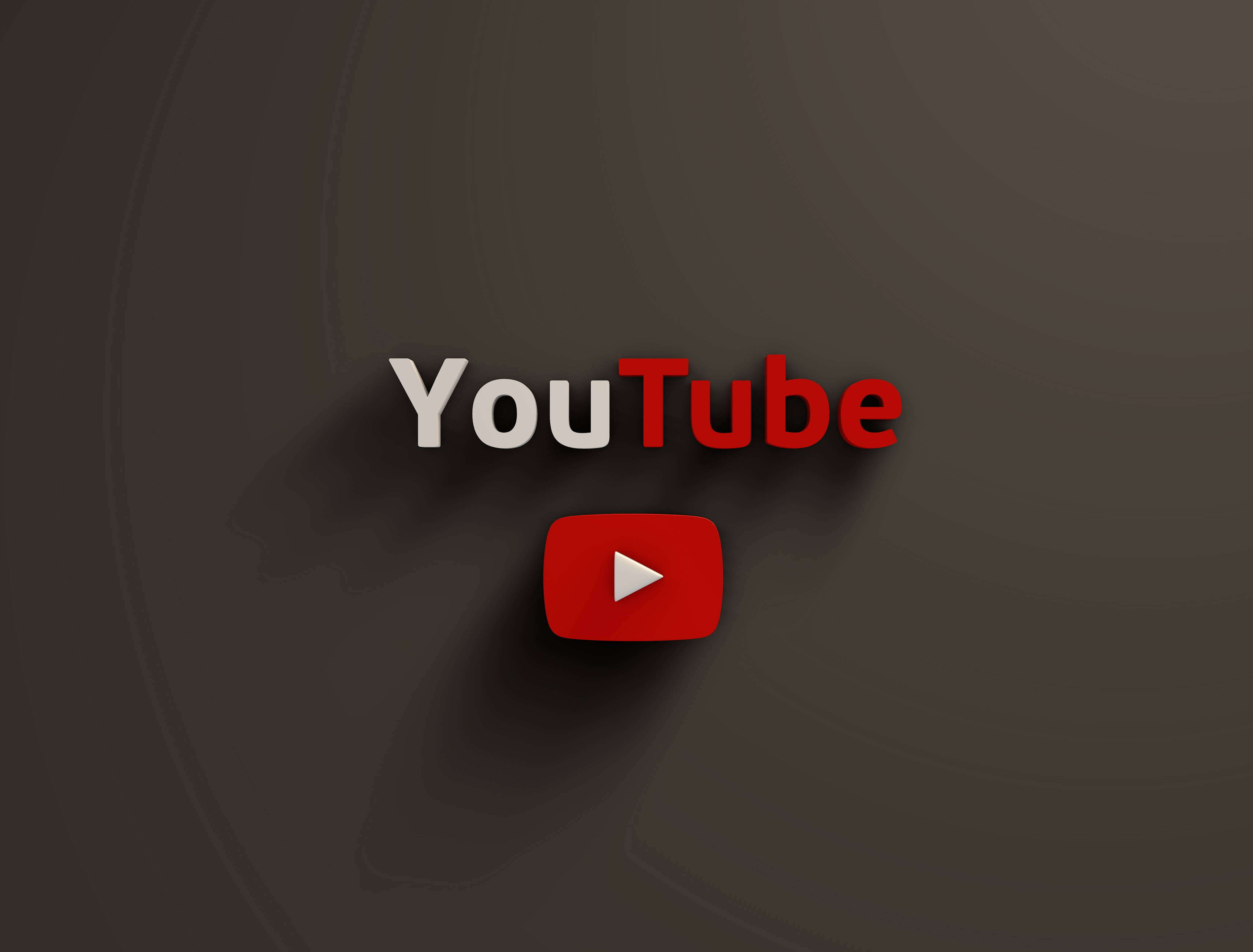 YouTube標誌於深灰色背景 壁紙 — YouTube 標誌，紅色播放按鈕居中，位於深灰色漸變背景上，帶有柔和陰影。