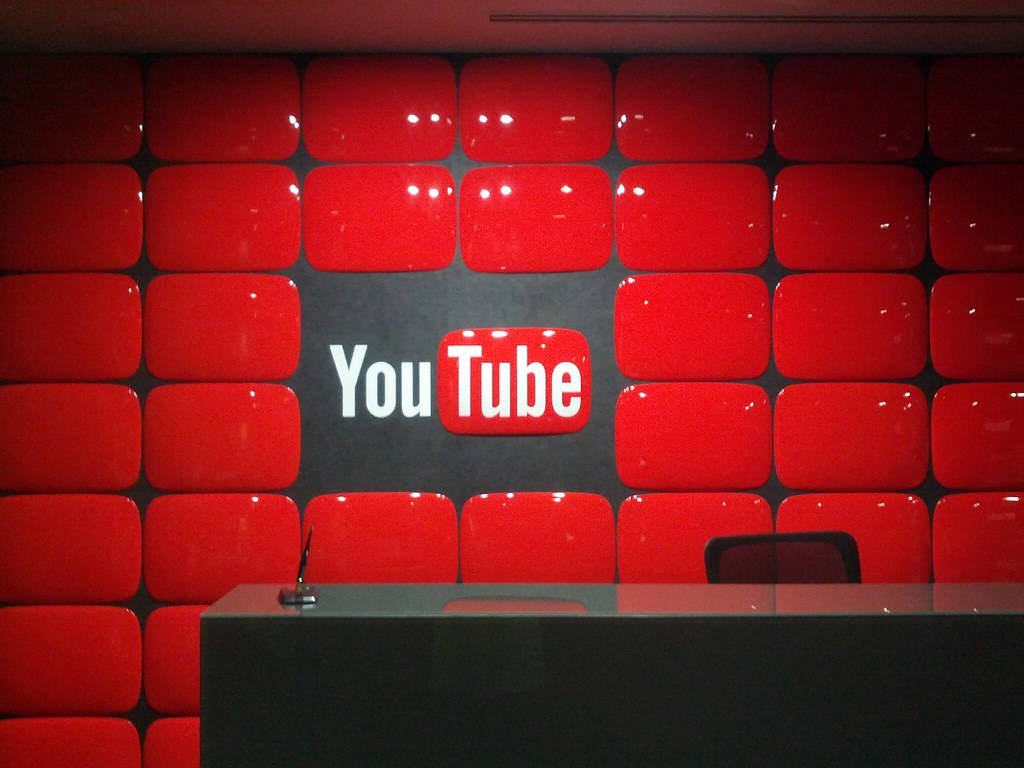 接待桌後方的紅色播放按鈕瓷磚牆上的 YouTube 標誌。