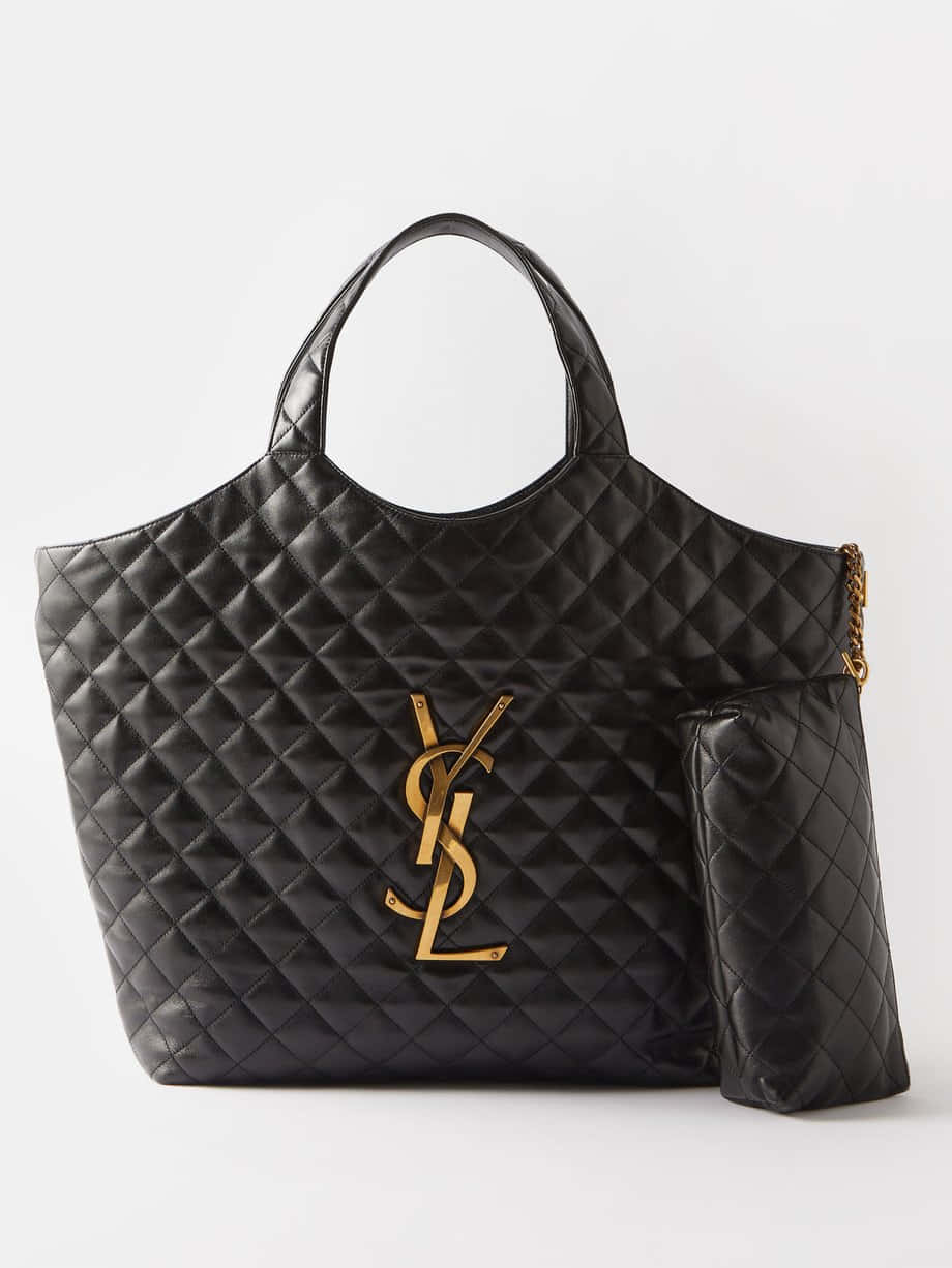 YSL：重新定義時尚、美學與風格 壁紙 — 黑色絎縫皮革YSL托特包，帶金色標誌和鏈條肩帶，白色背景。