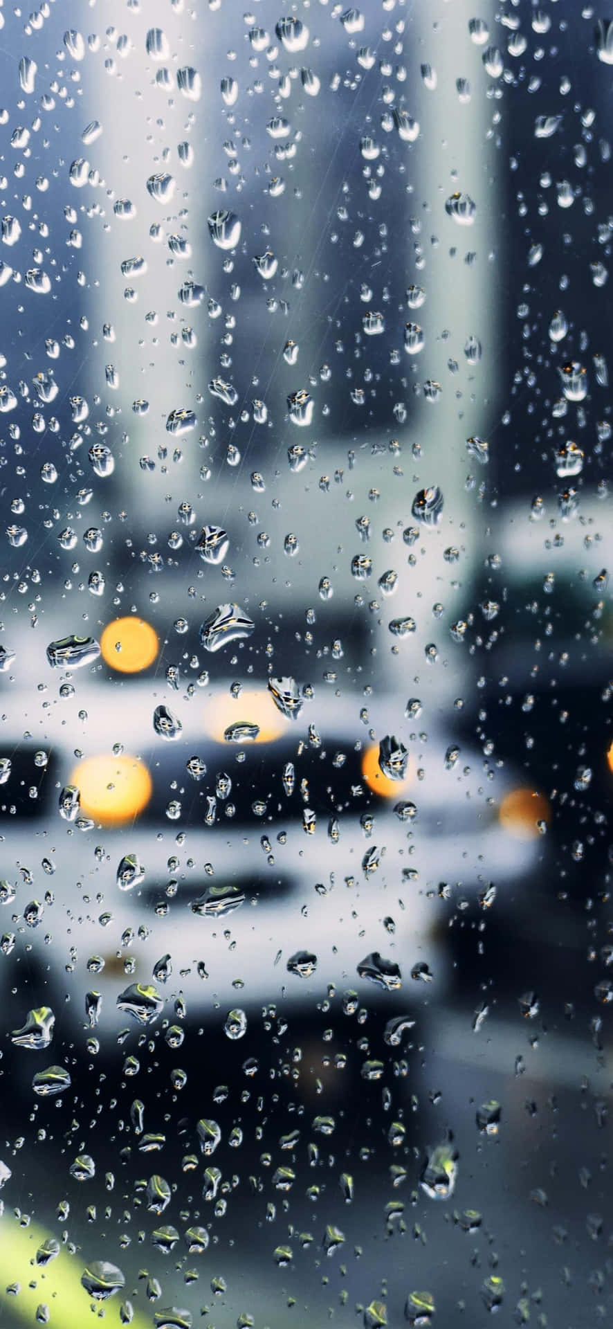  壁紙 — 雨滴劃過窗戶，顯露出模糊的城市燈光和傾盆大雨中駛過的汽車。