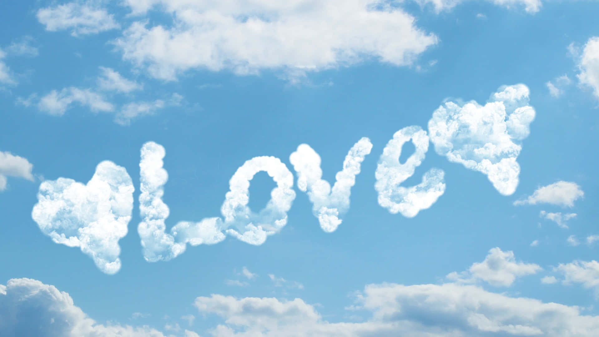  壁紙 — 在清澈的藍天上用 fluffy 白色雲朵拼出 love 這個詞，並有心形雲朵點綴。