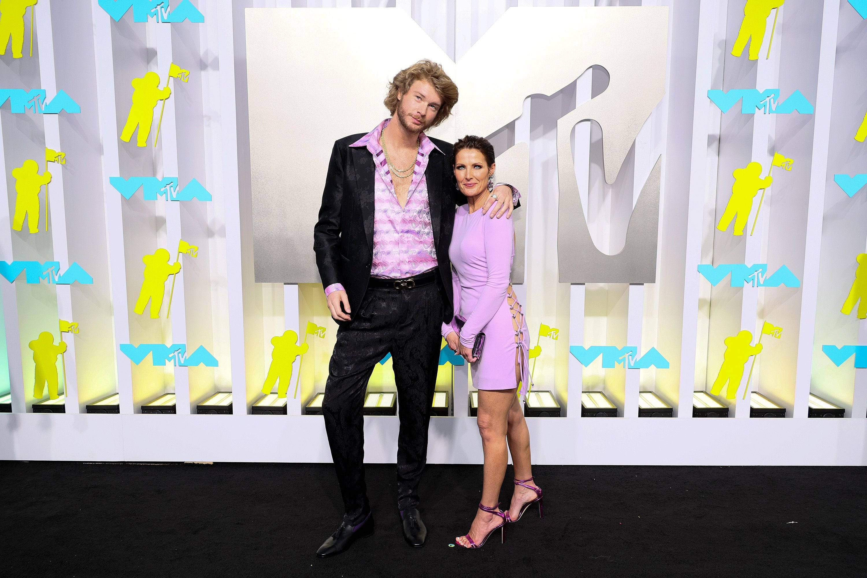 Yung Gravy 與前女友出席 MTV 活動 壁紙 — 一名男子和女子在MTV活動中，在充滿活力的黃白品牌背景前合影。