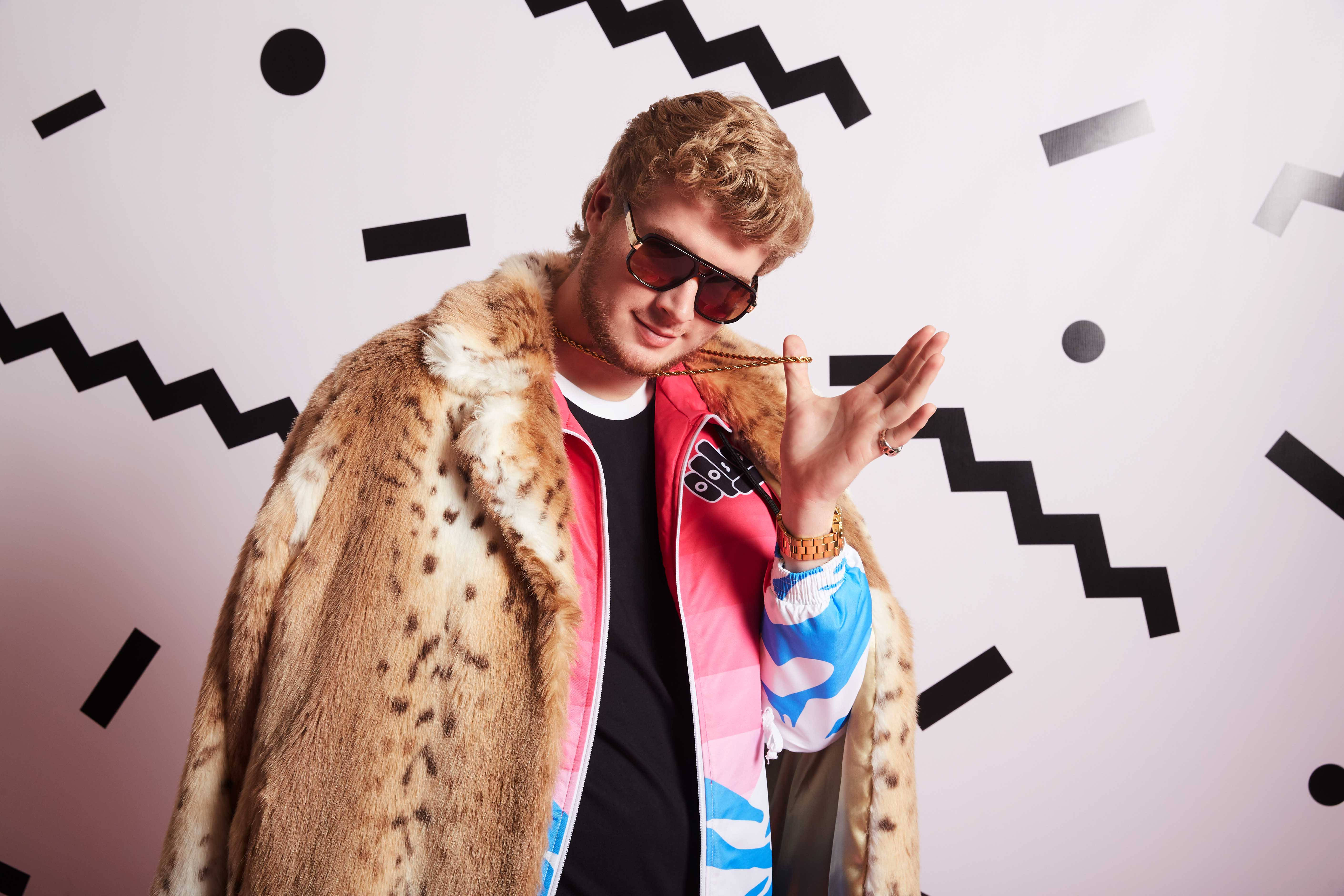 Yung Gravy 音樂錄影帶封面 壁紙 — 一位穿著斑點皮草外套和太陽眼鏡的時尚年輕男子，在鮮明的幾何背景前自信地擺姿勢。