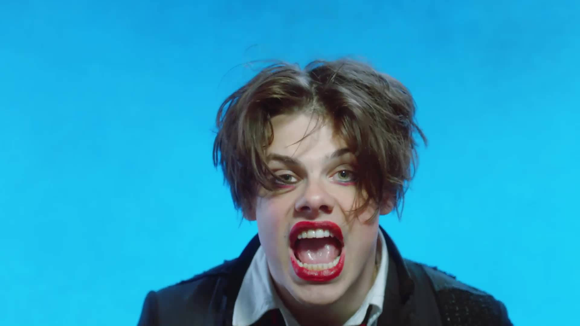 在藍色背景前尖叫的紅唇人物