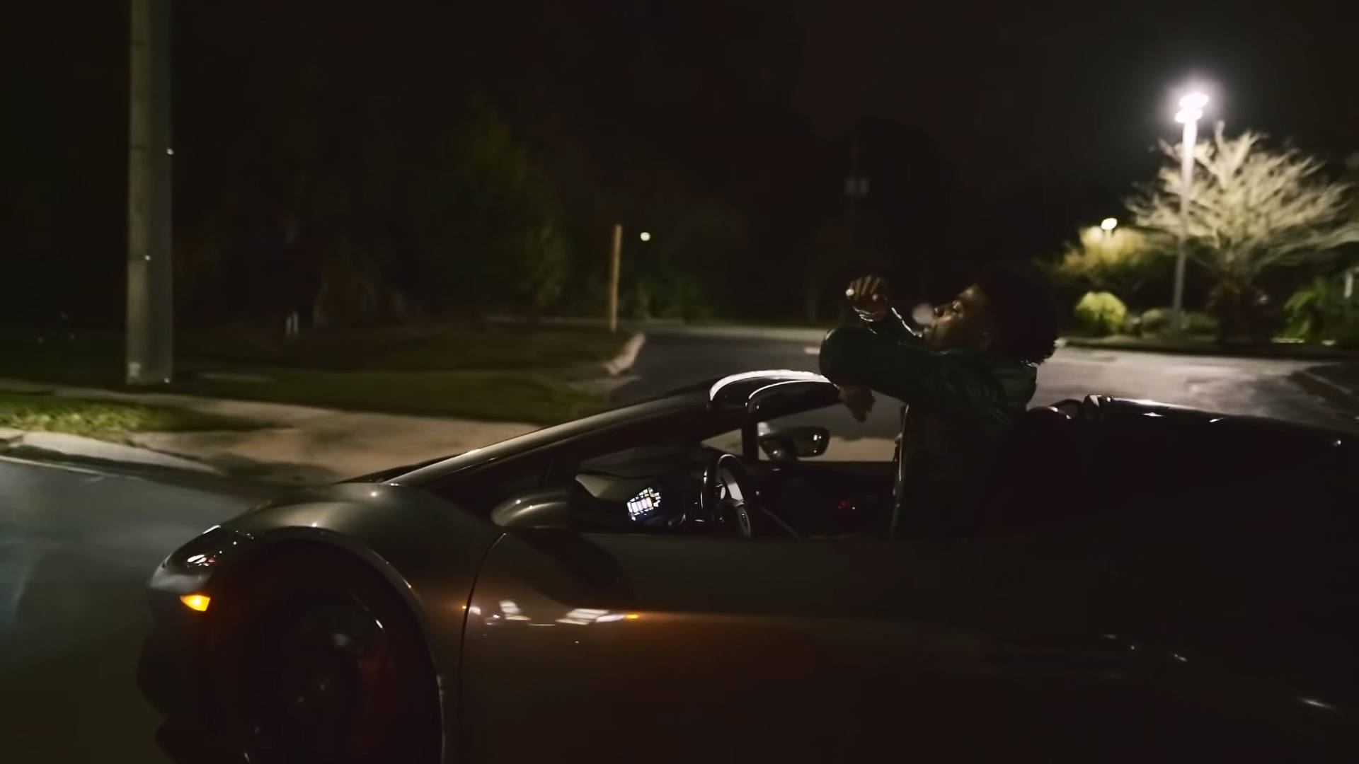 夜晚在街上黑色開篷車中慶祝的人。