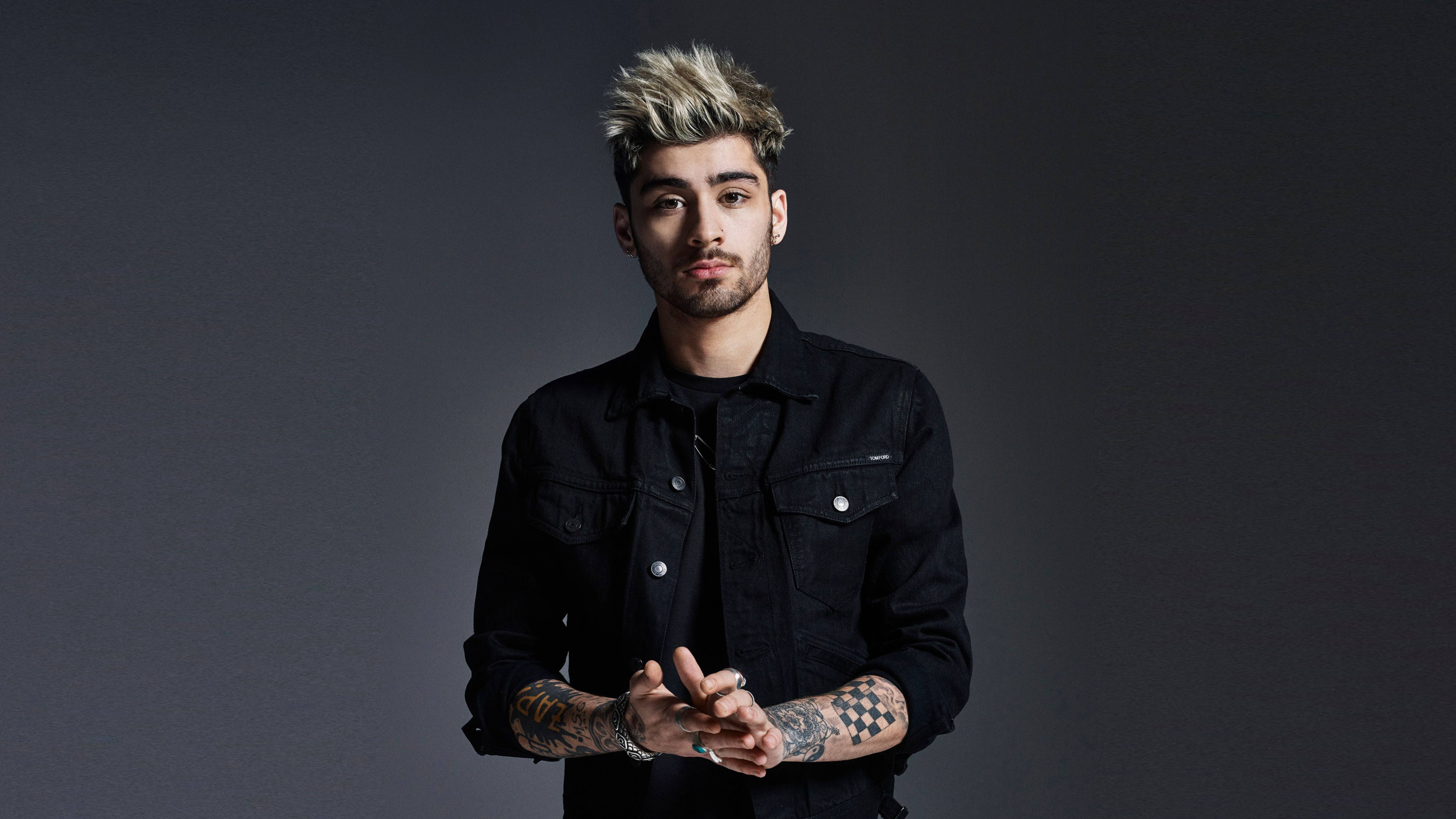 Zayn Malik 2016 首張專輯發行 壁紙 — 一位擁有尖刺金髮和紋身的年輕男子，在深灰色工作室背景前自信地凝視著鏡頭。