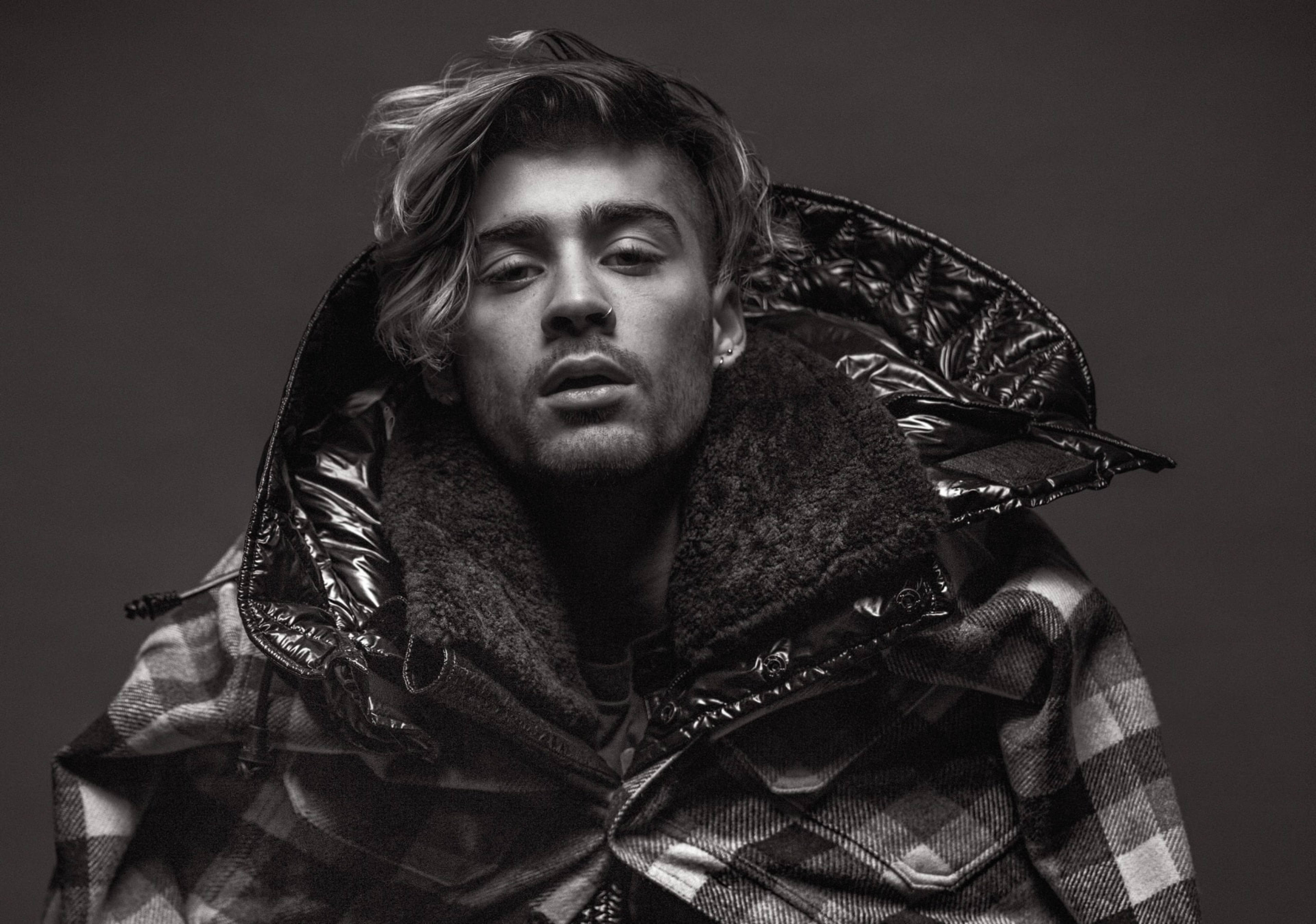 Zayn Malik VMan 2017 名人封面 壁紙 — 一個男人穿著格紋外套，戴著毛領連帽，在深色背景下的黑白肖像。