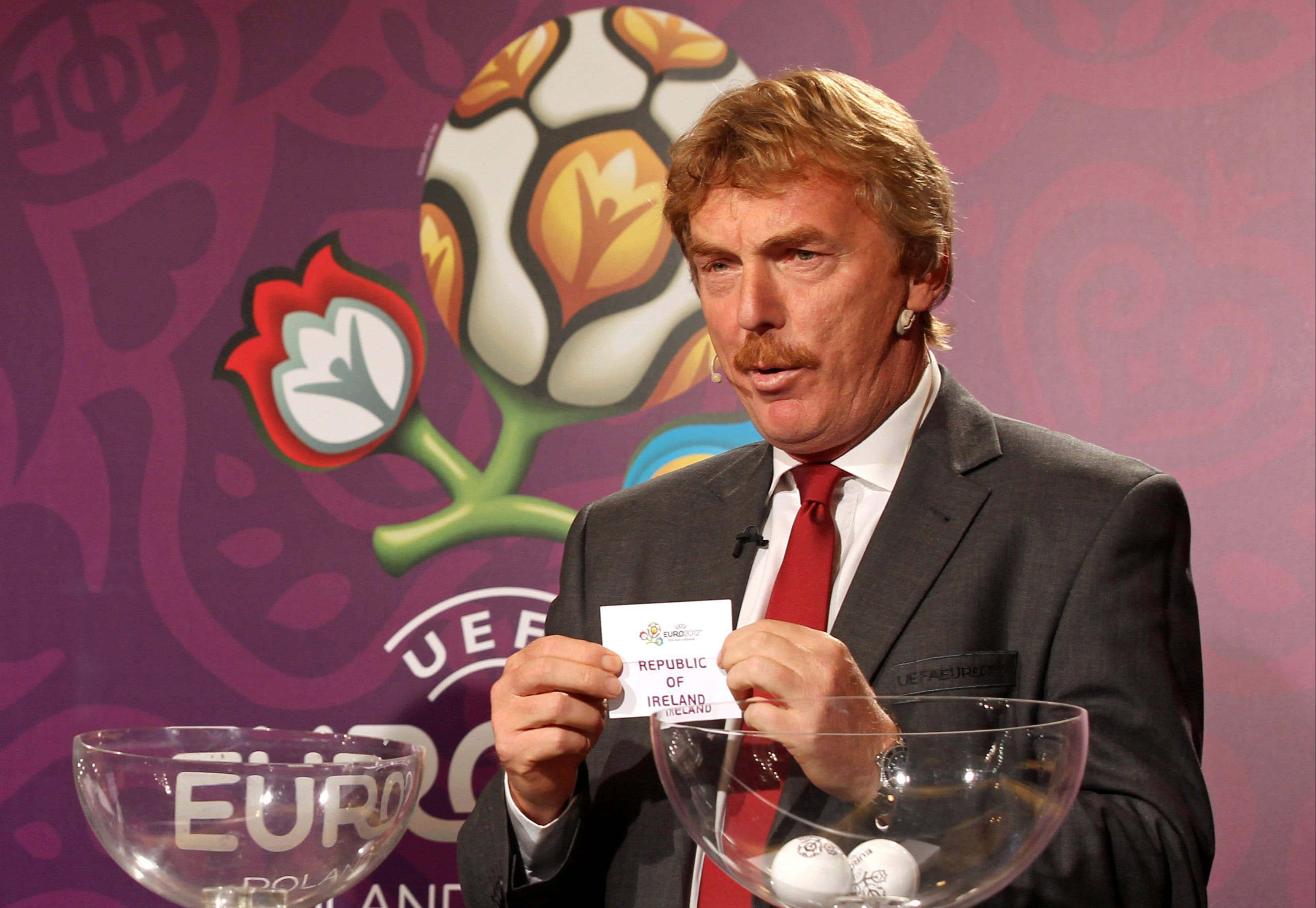 Zbigniew Boniek 在2012年歐洲杯期間為愛爾蘭共和國畫圖 壁紙 — 一名身穿西裝的男子站在帶有足球標誌的UEFA Euro 2012品牌背景前，手持寫有Republic of Ireland的卡片。