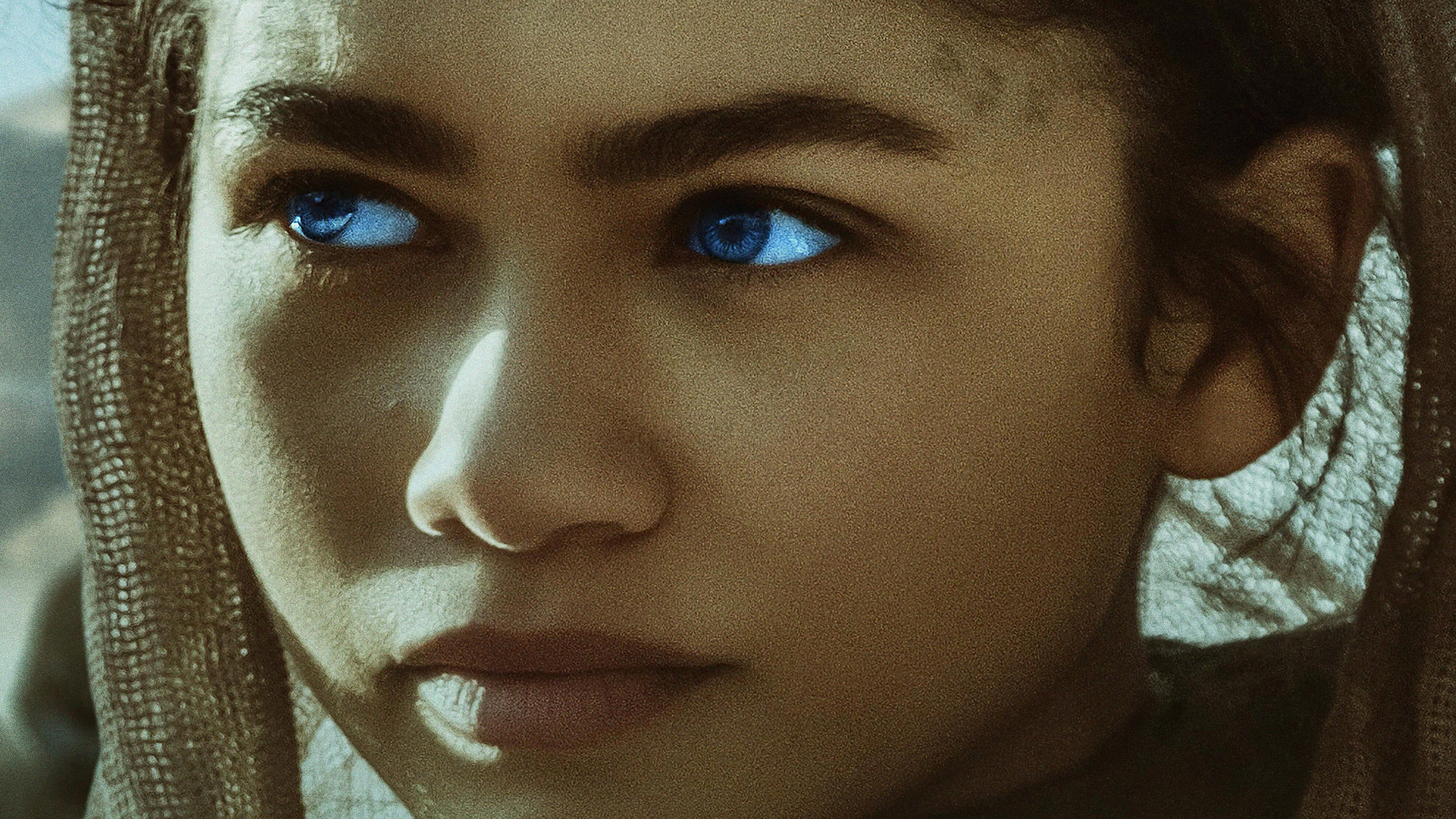 Zendaya 飾演 Chani《沙丘》2021 壁紙 — 年輕女子的特寫肖像，擁有引人注目的藍色眼睛和帶有紋理的面紗，專注地凝視，表情嚴肅。