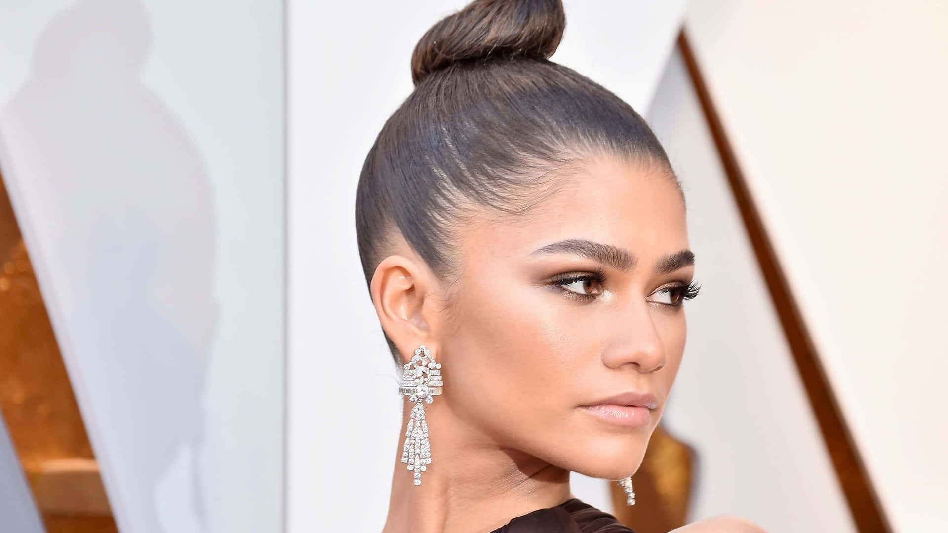 Zendaya 在正式活動中戴著華麗的鑽石耳環和高髻。