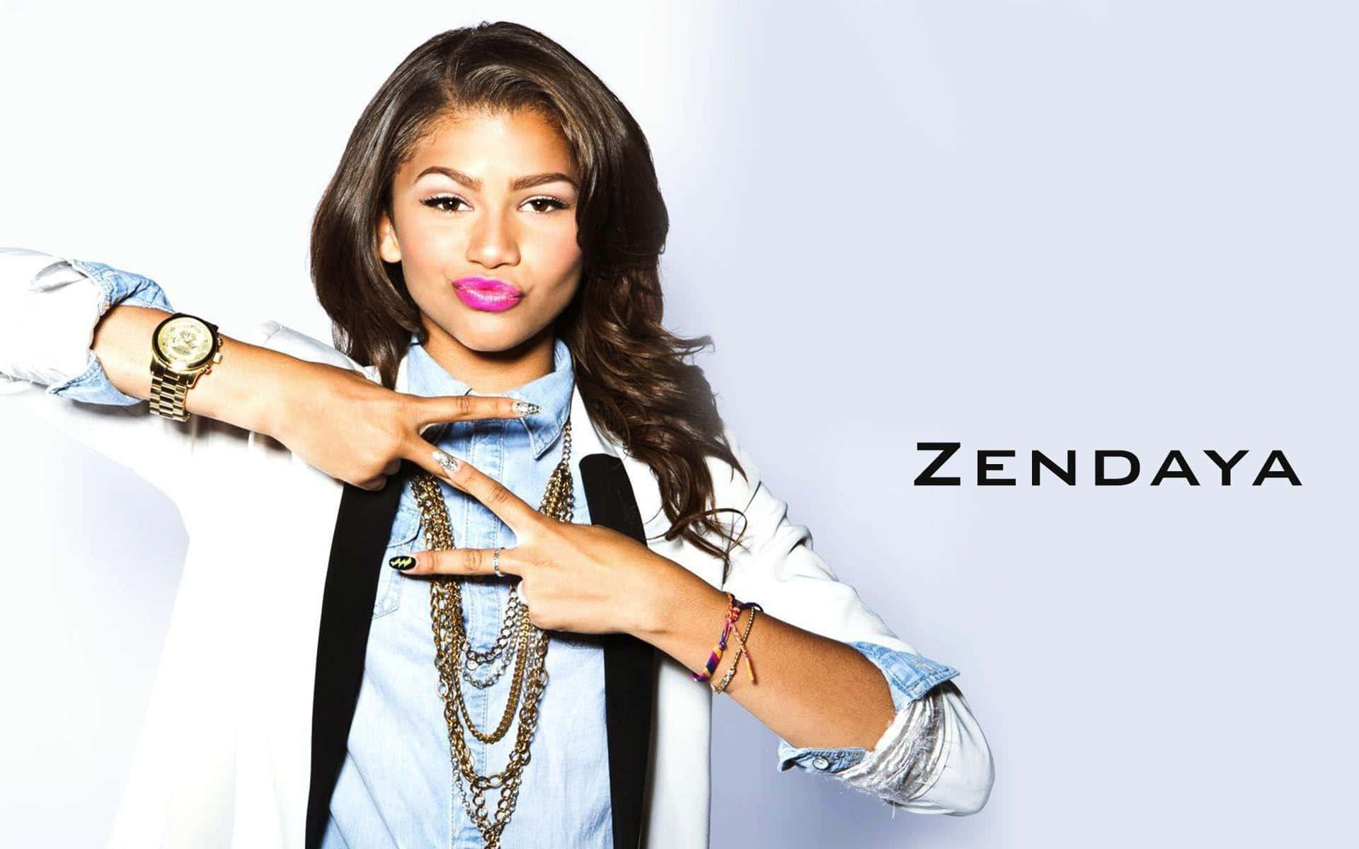 Zendaya 桌布 壁紙 — Zendaya 自信地擺姿勢，雙手做出和平手勢，背景是純淺灰色。