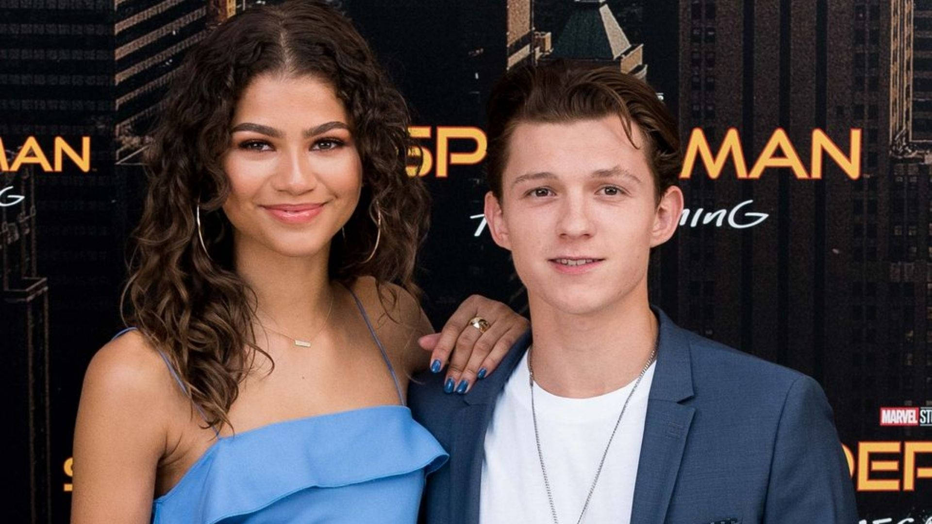 Zendaya 與 Tom Holland 壁紙 — Zendaya 和 Tom Holland 在《蜘蛛俠：不戰無歸》首映禮上，以城市天際線為背景，對著鏡頭微笑。