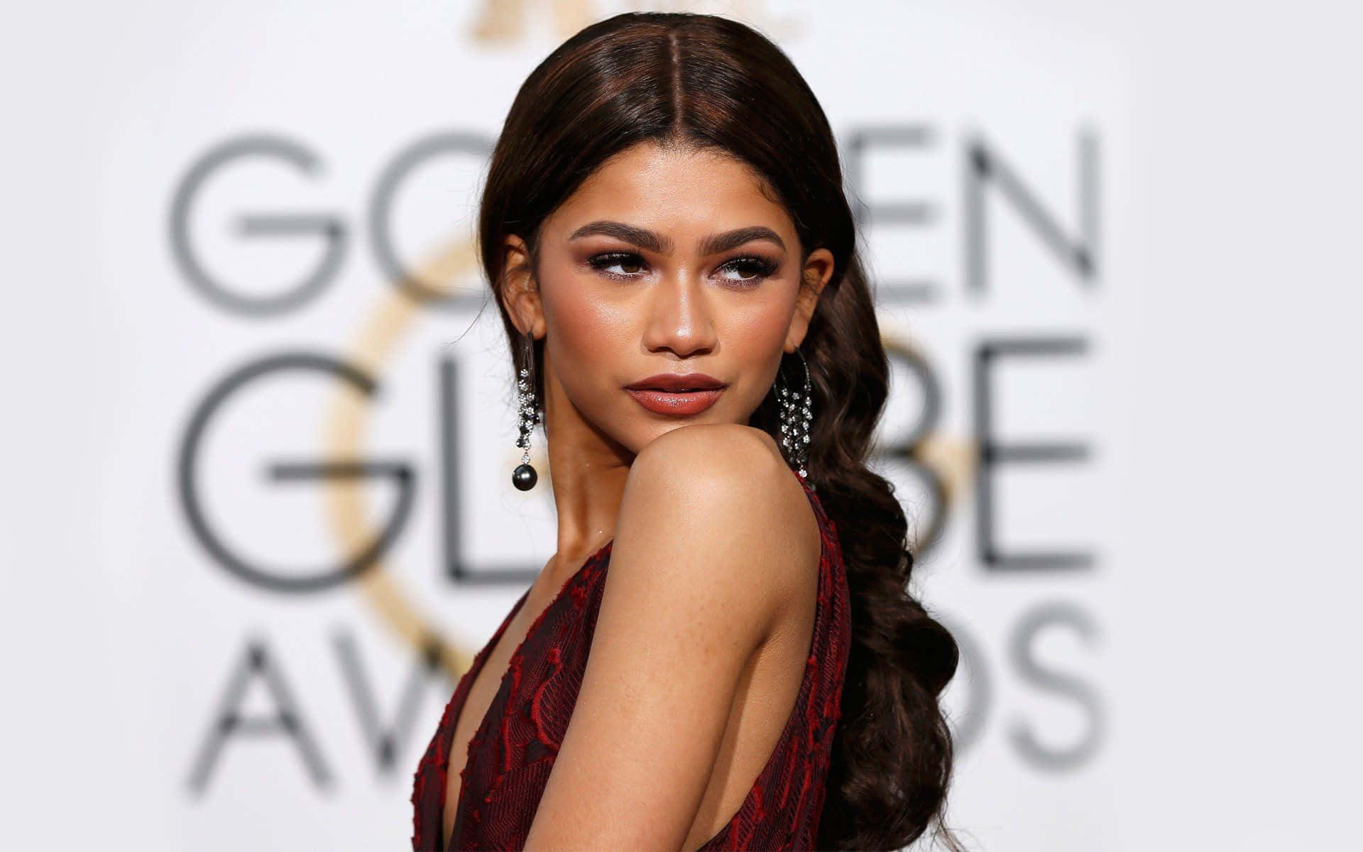 Zendaya 在金球獎紅地毯活動中穿著紅色長裙。