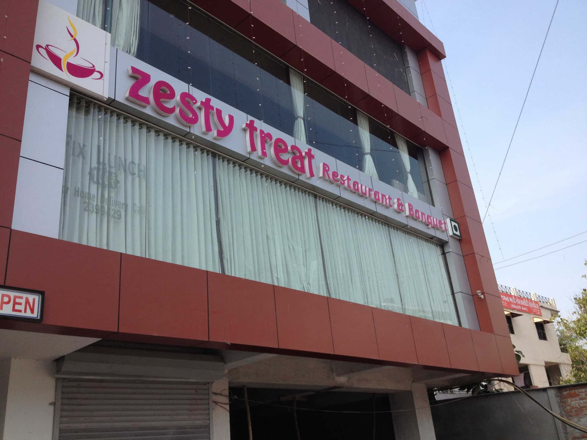 紅白餐廳建築，帶有「Zesty Treat」招牌和營業中招牌。