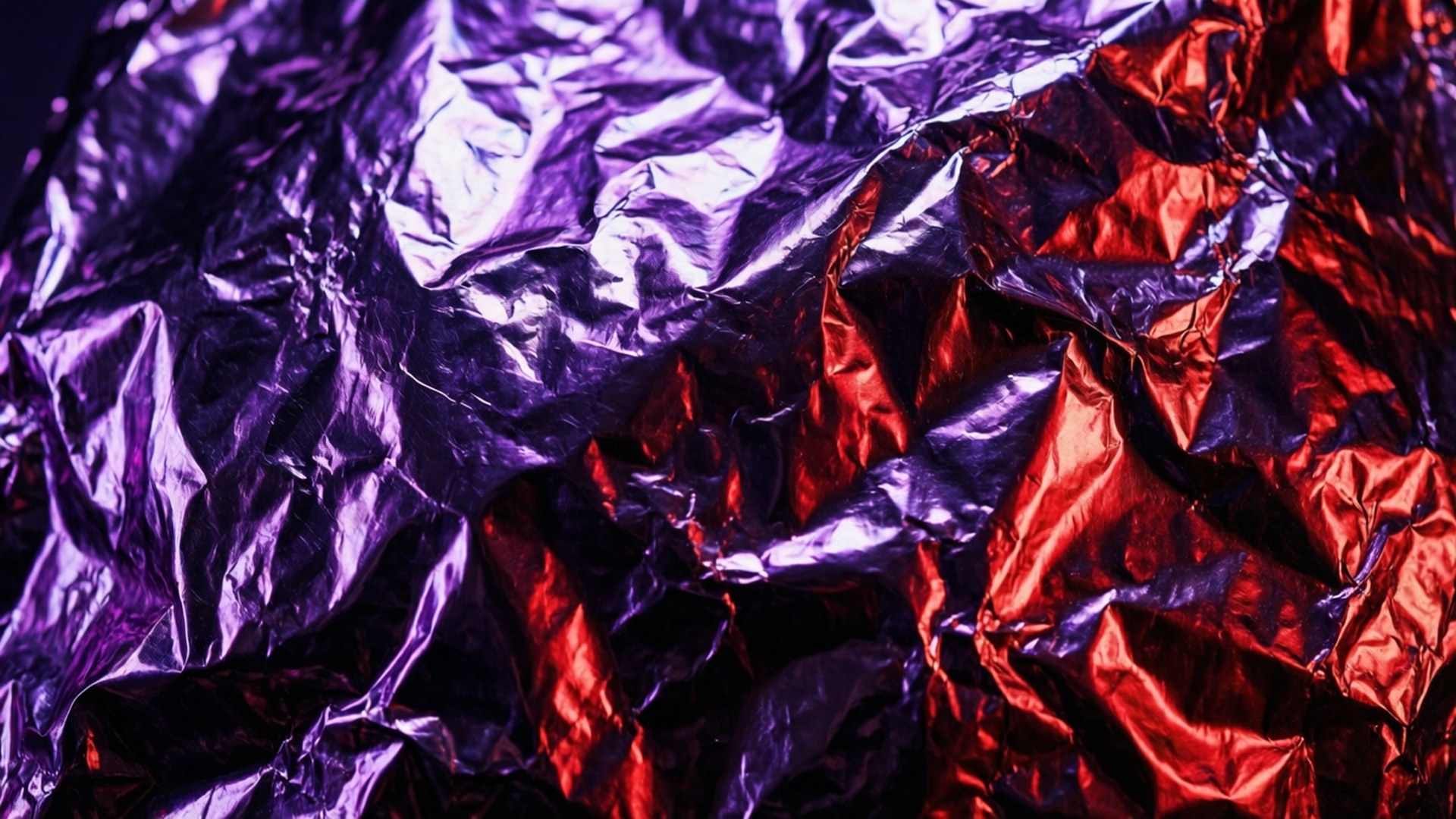 Takis 桌布 壁紙 — 皺巴巴的金屬箔片，帶有鮮豔的紫色和紅色色調，在紋理化的抽象圖案中反射光線。
