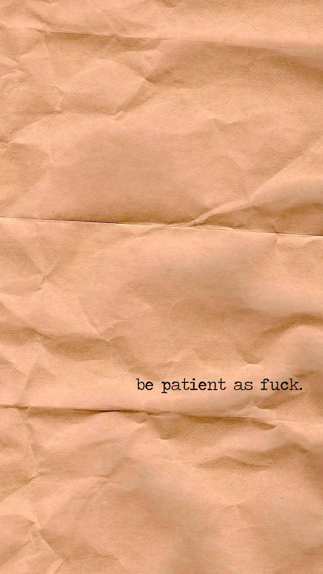 皺巴巴的棕色紙張，上面有黑色印刷的短語 be patient as fuck。