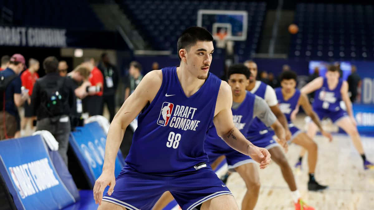  壁紙 — 一名專注的籃球運動員穿著藍色 'Draft Combine' 球衣，在專業選秀觀察活動中激烈運球。
